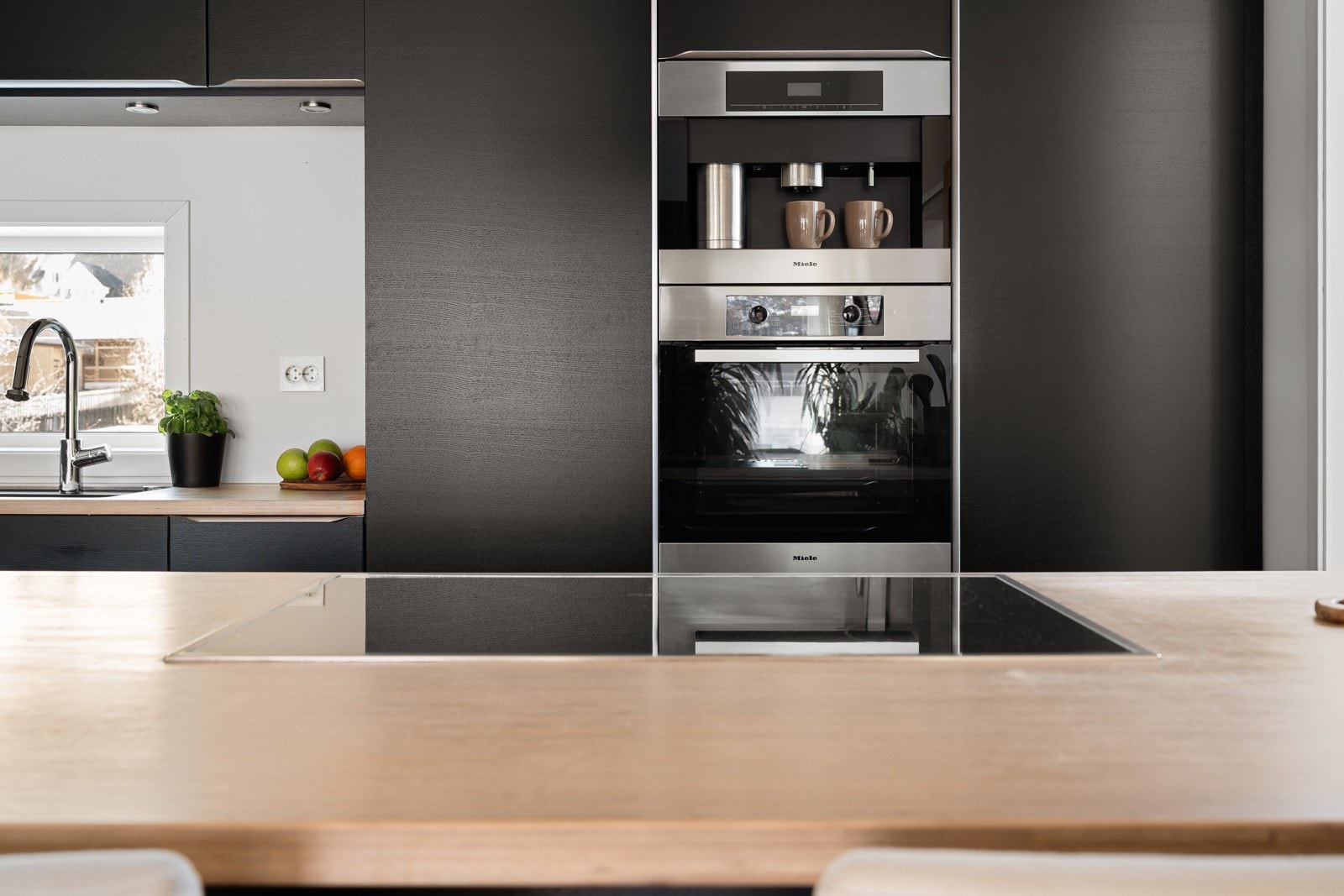 Integrerte hvitevarer av høy kvalitet og benkeplate bambus. Hel kjøl og hel frys på hver sin side av Miele stekeovn og integrert kaffemaskin.