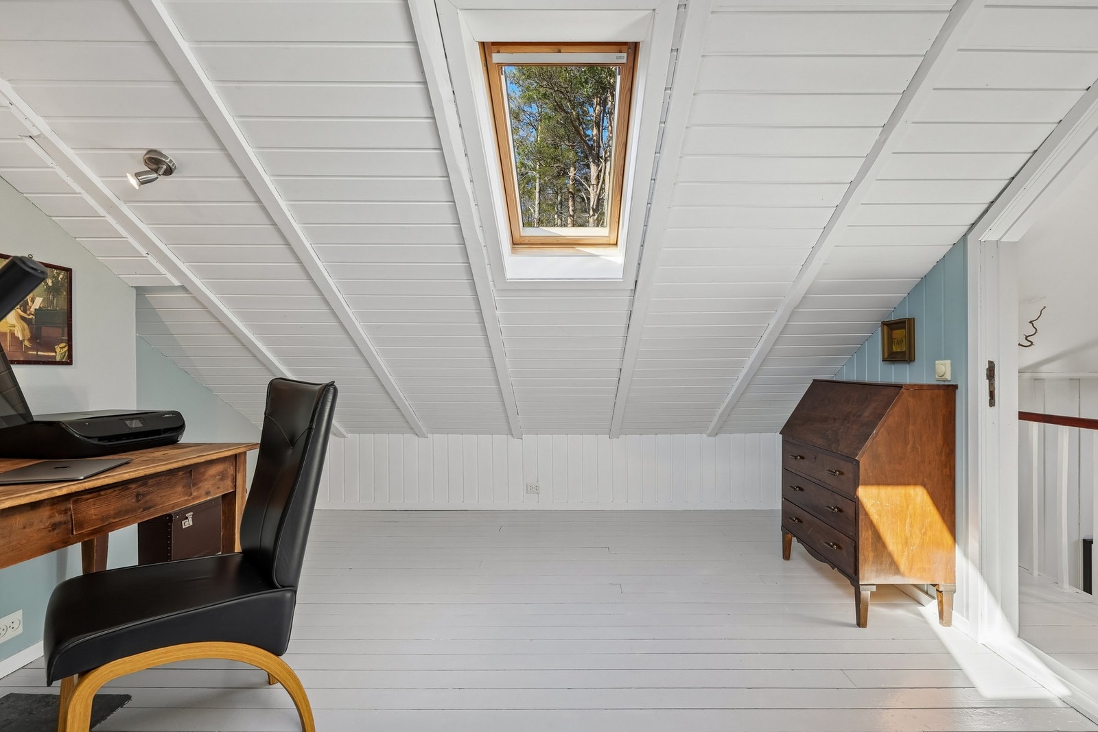 Lyst loftsrom med skråtak og takvindu som gir godt med naturlig lys. Tregulv og på veggene og i himling er det malt panel. (Rommet er ikke godkjent for varig opphold) Galleribilde