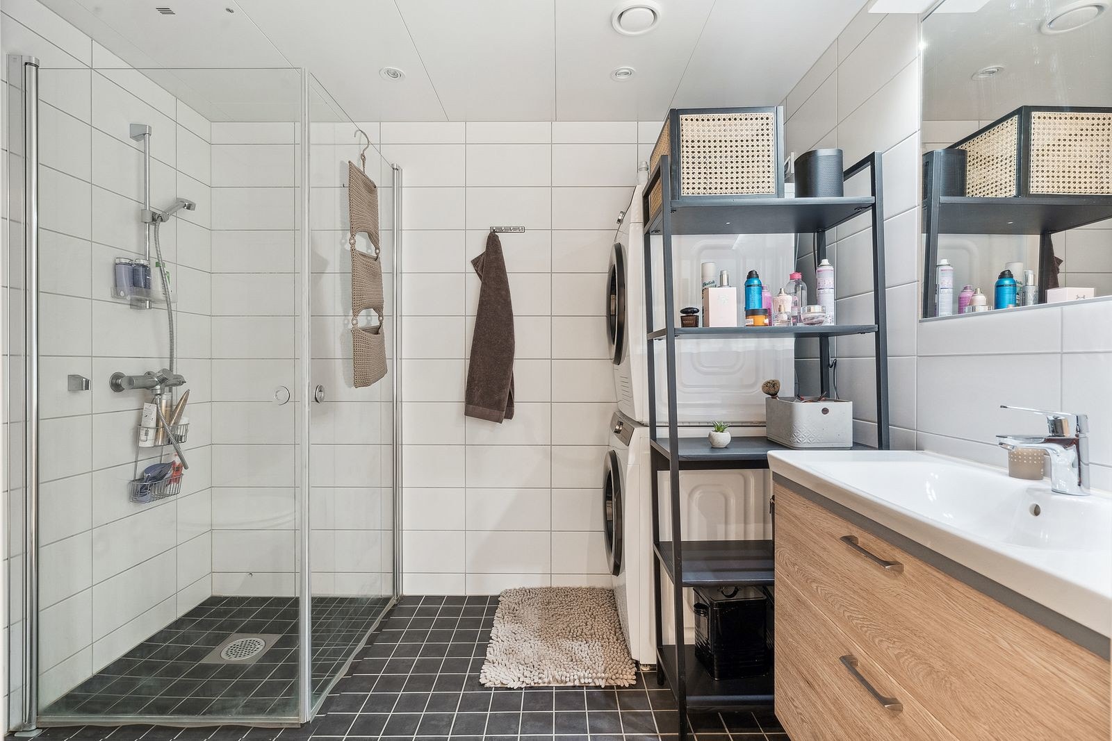 Moderne og komplett flislagt bad, med vaskemaskin og tørketrommel.