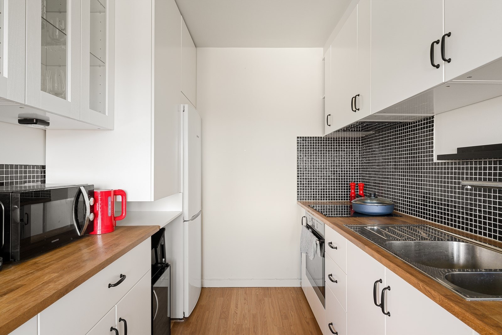 Romslig kjøkken med stilrent design, optimal plassutnyttelse og tidløse overflater. Galleribilde