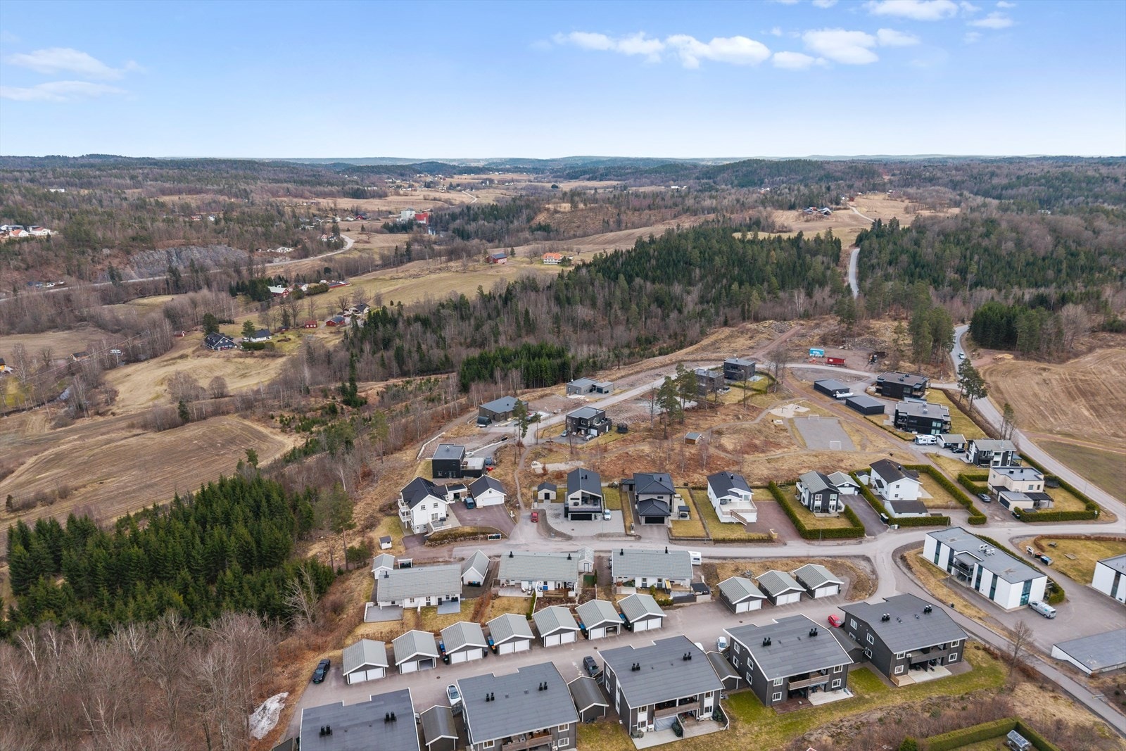 Eiendommen er omgitt av skog og har utsikt mot et åpent landskap. Galleribilde