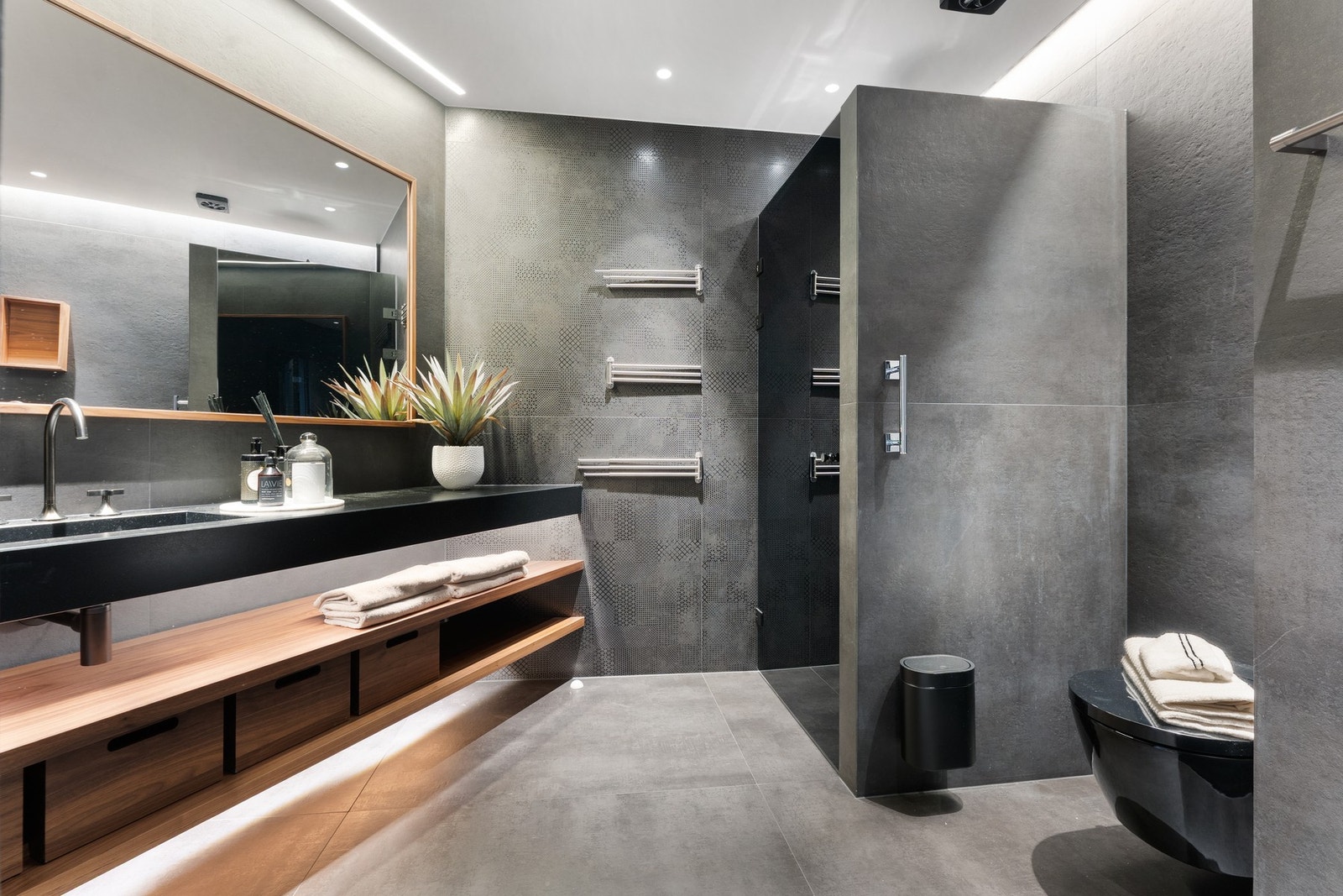 Hovedbadet, oppgradert i 2021, fremstår som et elegant og spa-inspirert rom med flislagte overflater, valnøttdetaljer og en sober, eksklusiv materialitet. Galleribilde