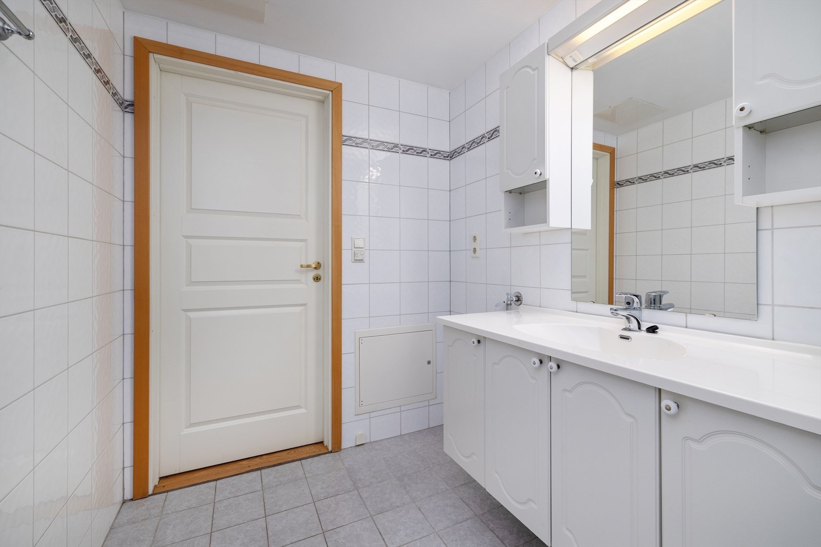 Badet er helfliset og utstyrt med servantinnredning, speil med belysning og vegghengte skap. Galleribilde