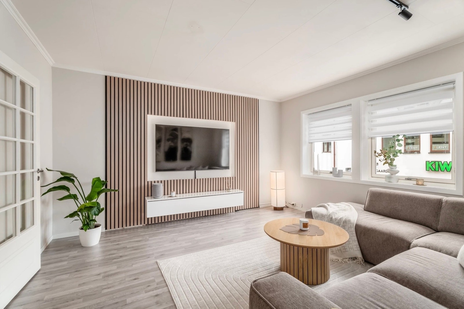 Døren mellom stue og gang har glassfelt med sprosser som sikrer lysinnslipp til gangen. Elegant vegg med spiler og vinduskarmer som er brede nok til dekorobjekt om ønskelig. Galleribilde