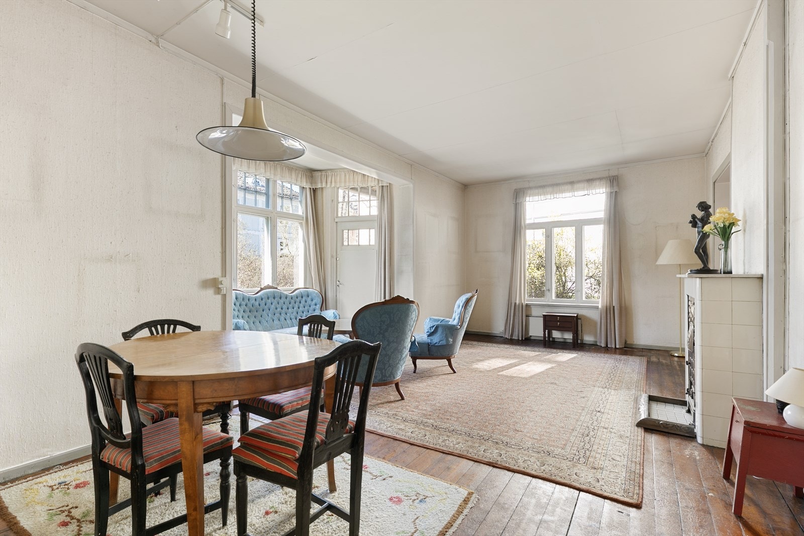 Stuen i 1. etasje fremstår som et lyst og romslig oppholdsrom med god takhøyde og store vindusflater som slipper inn rikelig med naturlig lys. Galleribilde