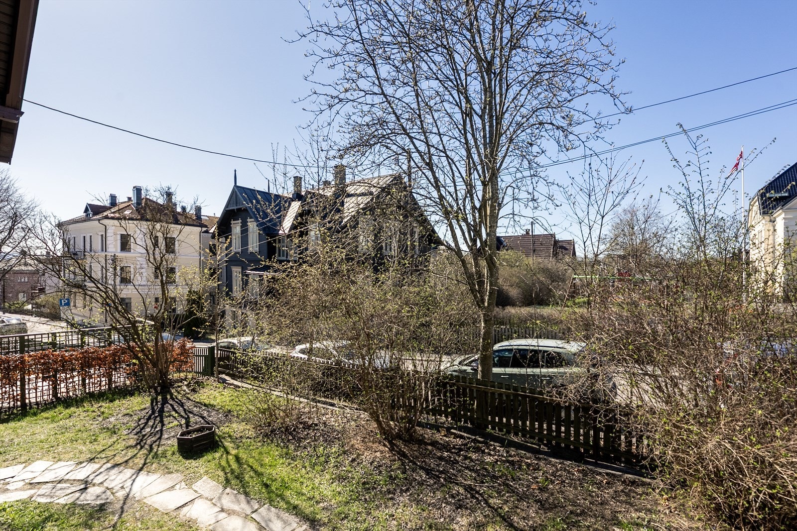 Tomten er opparbeidet med gressplen, beplantning og steinsatt internvei. Galleribilde