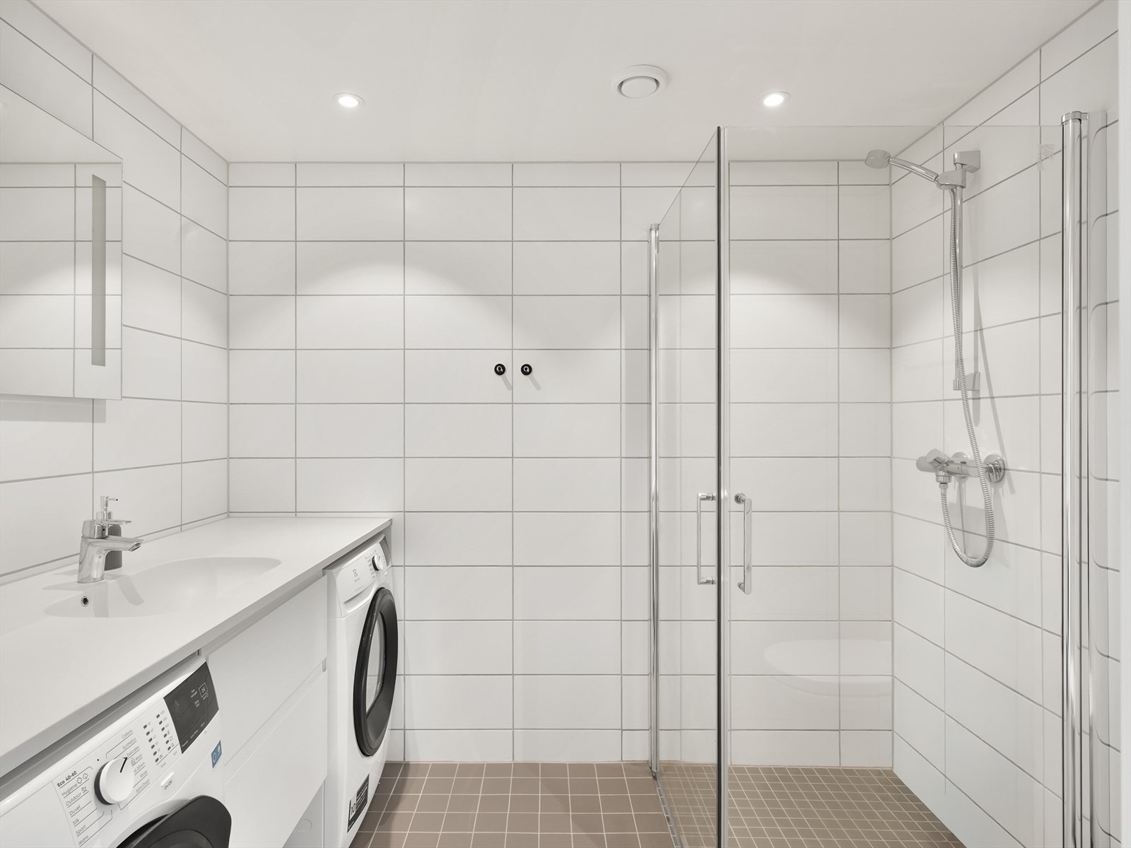 Dusjhjørne med innfellbare glassvegger og downlights i den nedsenkede himlingen. Galleribilde