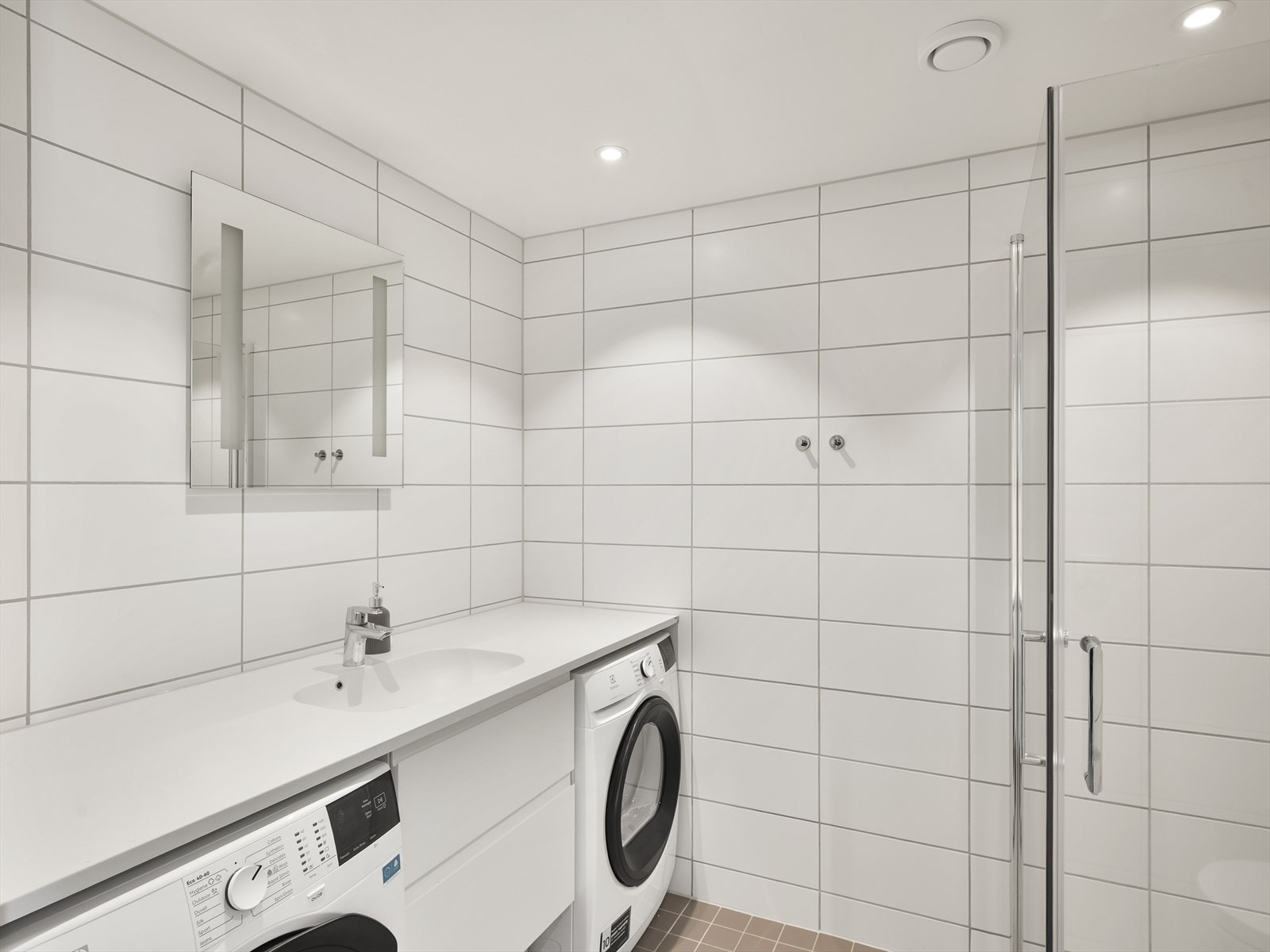 Badet er fra byggeåret 2021 og har flislagte overflater, gulvvarme og en praktisk benkeplate. Galleribilde