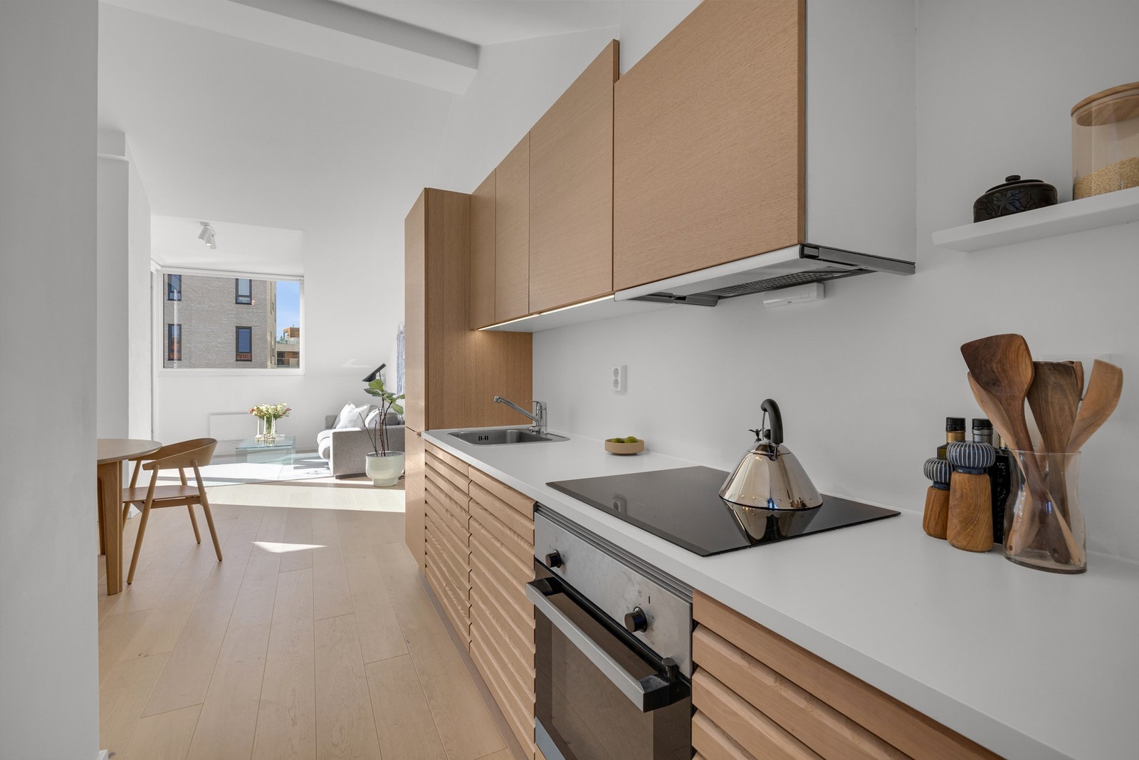 Kjøkkenet er moderne med HTH-innredning i glatte og profilerte fronter og laminat benkeplate med nedfelt kum i rustfritt stål. Galleribilde