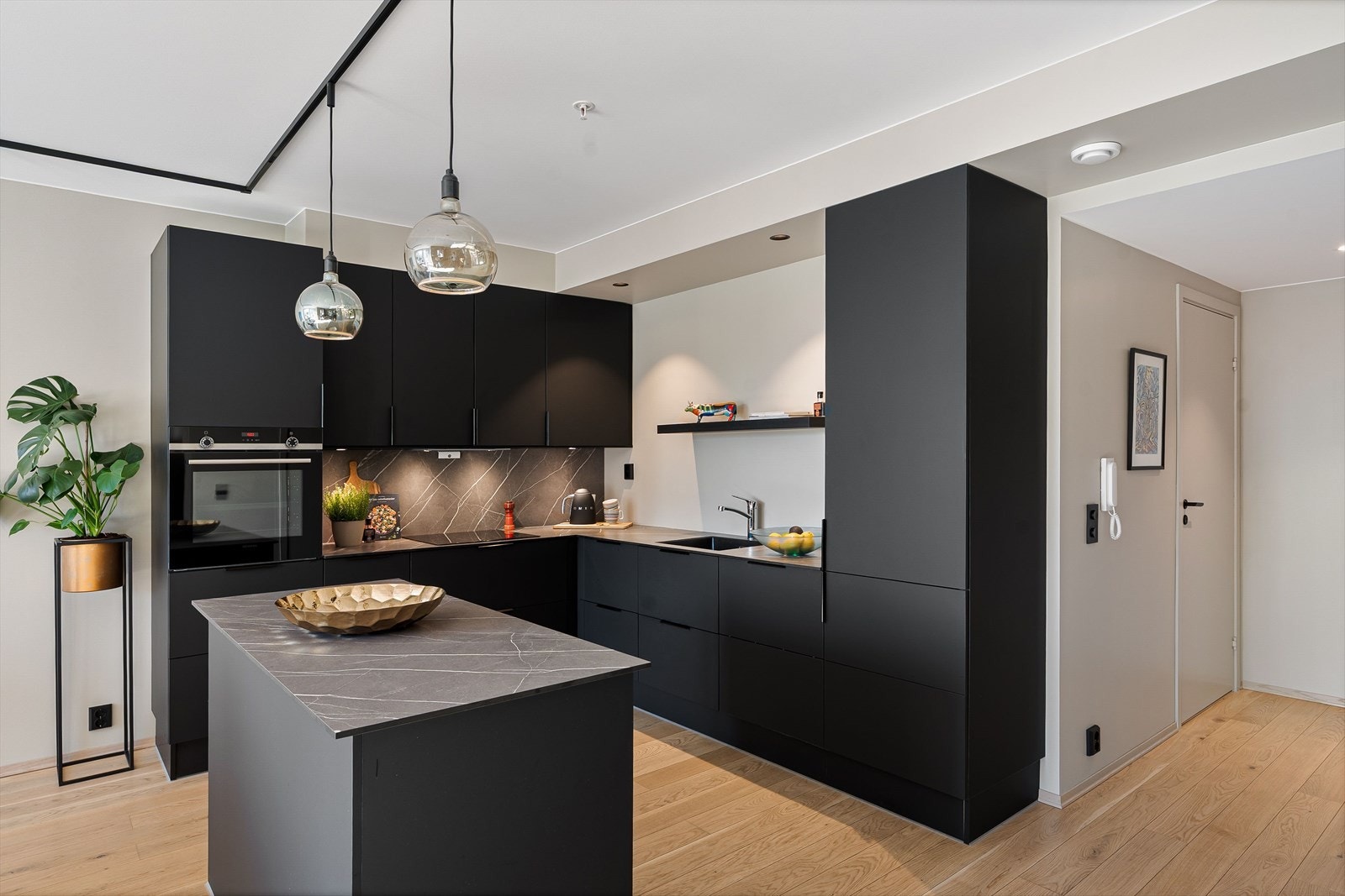 Kjøkkenet er levert av JKE Design og fremstår stilrent med mørke, matte fronter. Galleribilde