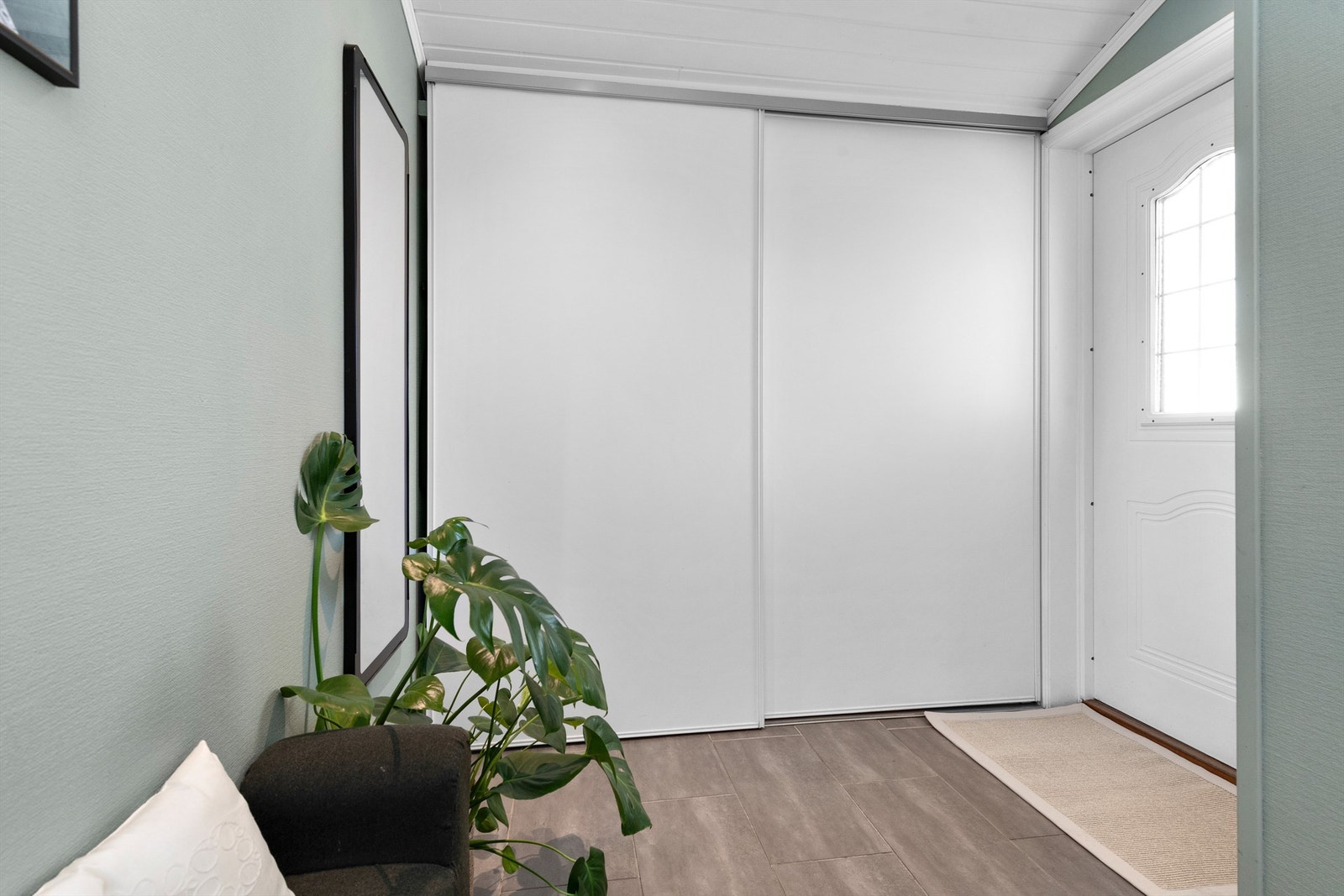 En stor skyvedørsgarderobe i vindfanget gir rikelig med plass til yttertøy og sko Galleribilde