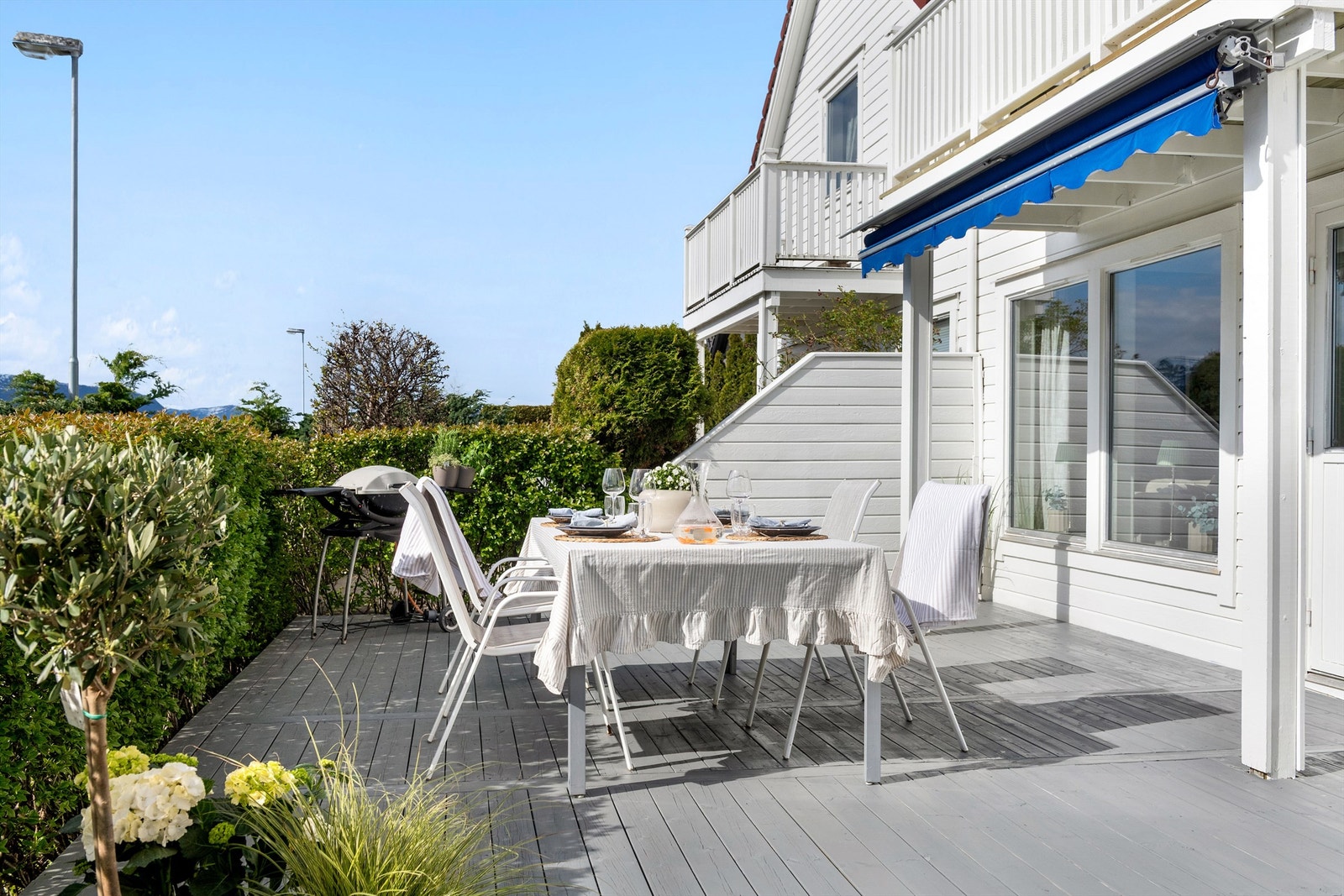 Her er det god plass til både spisebord og grill, skjermet av hekk og levegg mot nabo Galleribilde