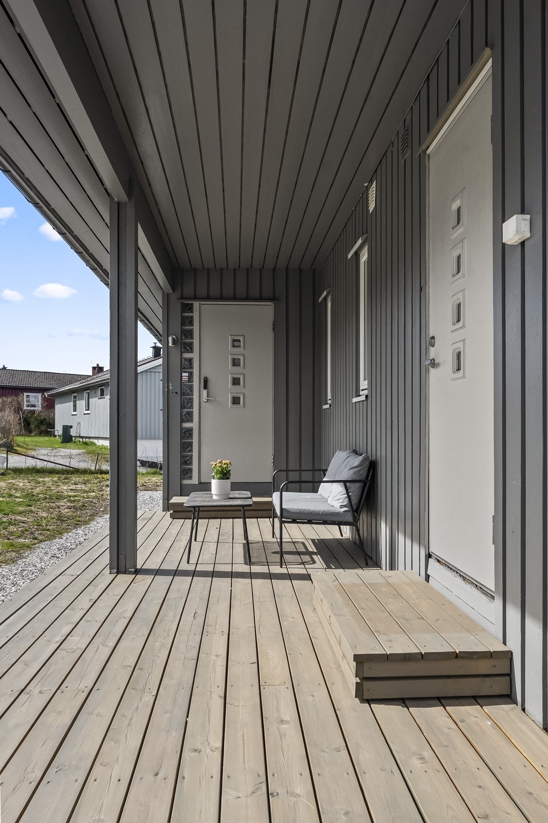 Overbygget inngangsparti med plass til en liten sittegruppe. Galleribilde