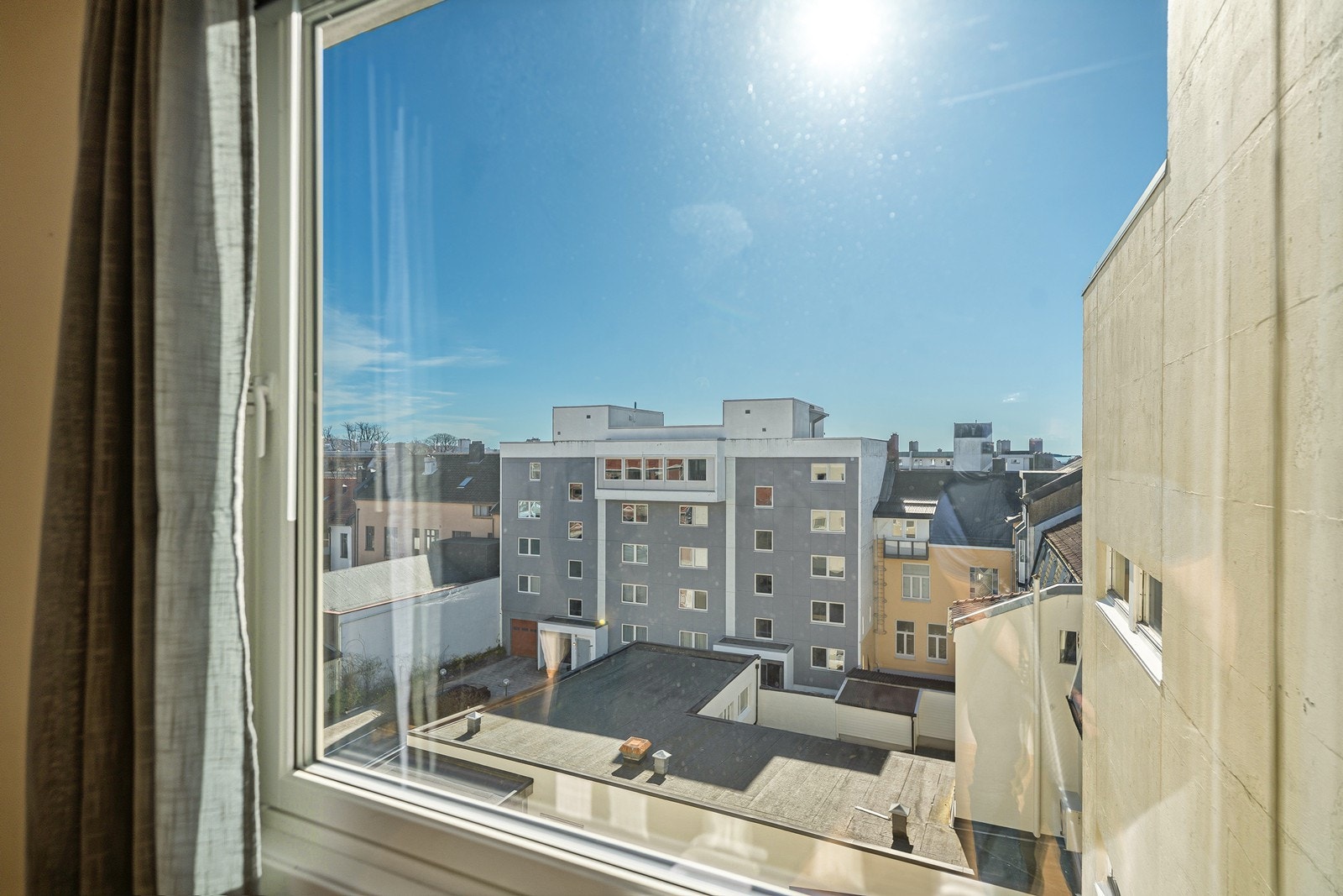 Fra stuen har du utsikt utover bakgården mot bystranda og Tresse Galleribilde