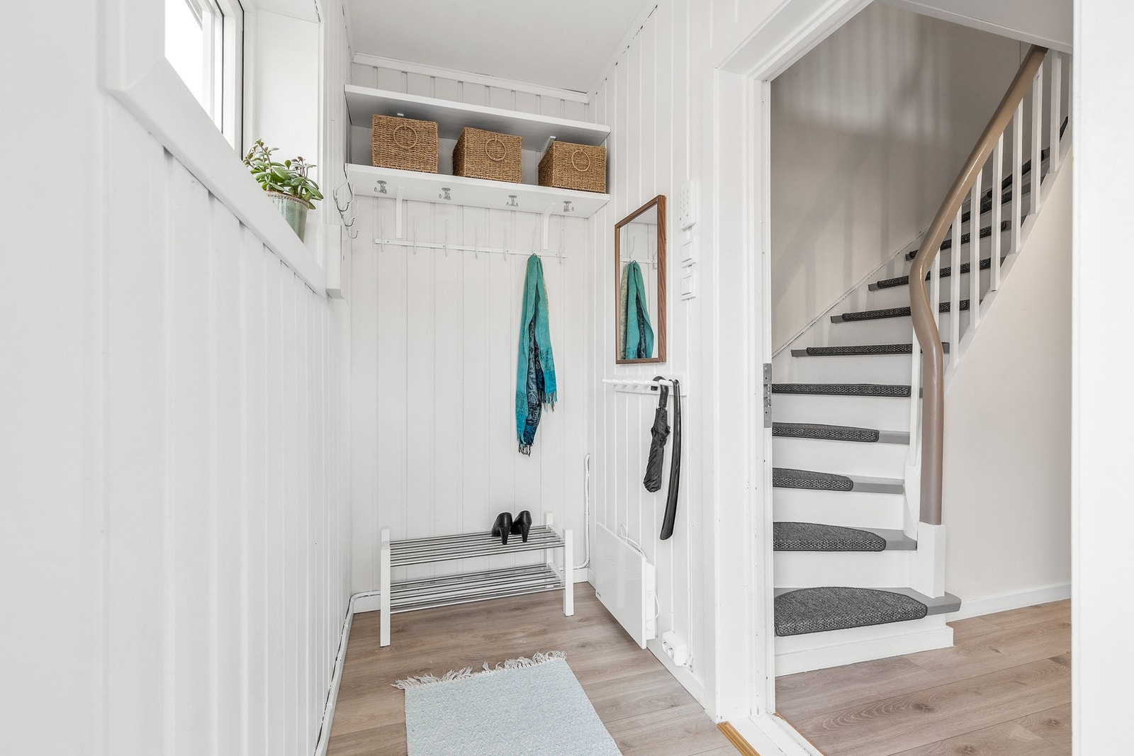 Entré med laminatgulv og praktisk oppbevaring med knagger og hyller. Galleribilde