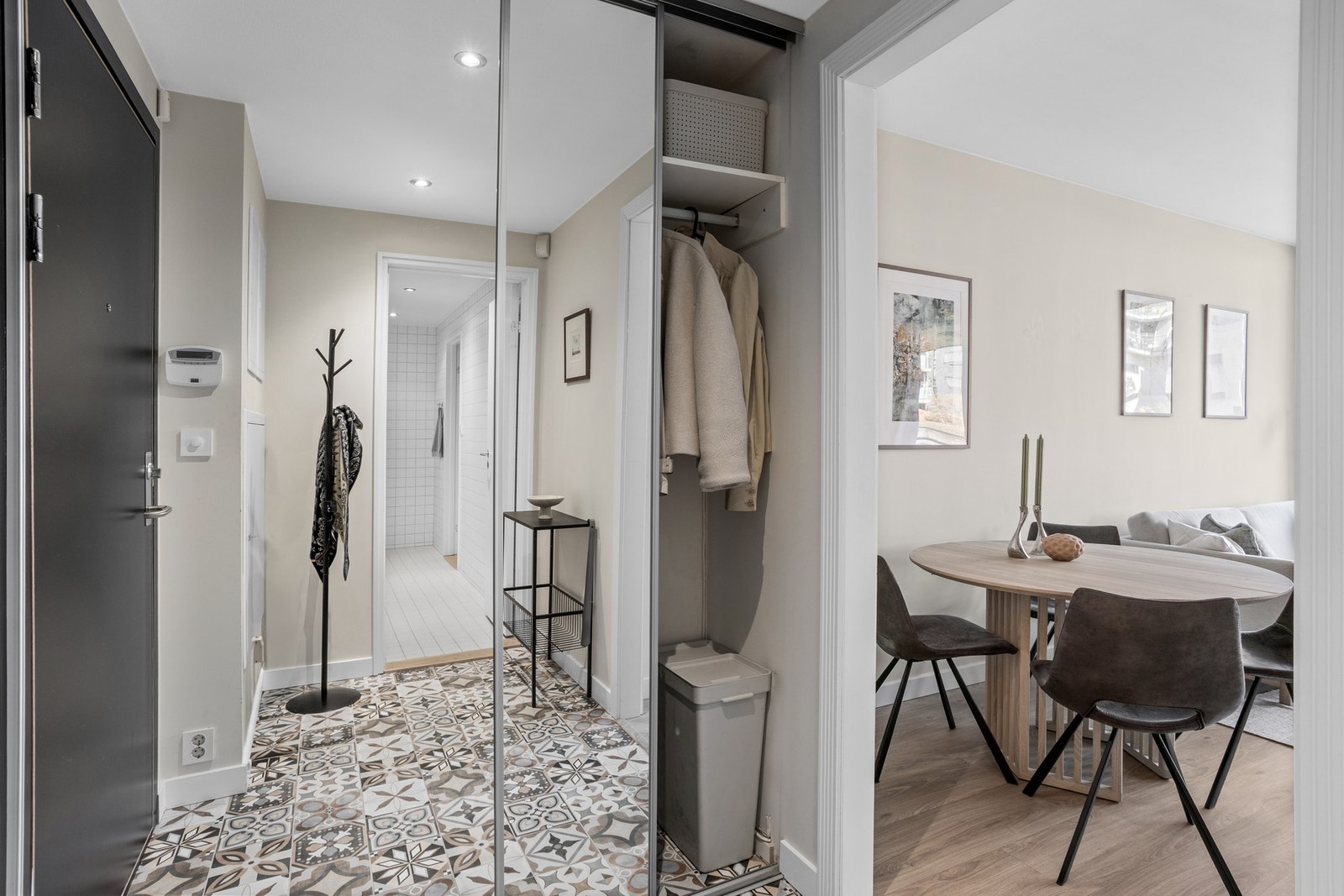 Entré med flislagt gulv og skyvedørsgarderobe med speilfronter Galleribilde