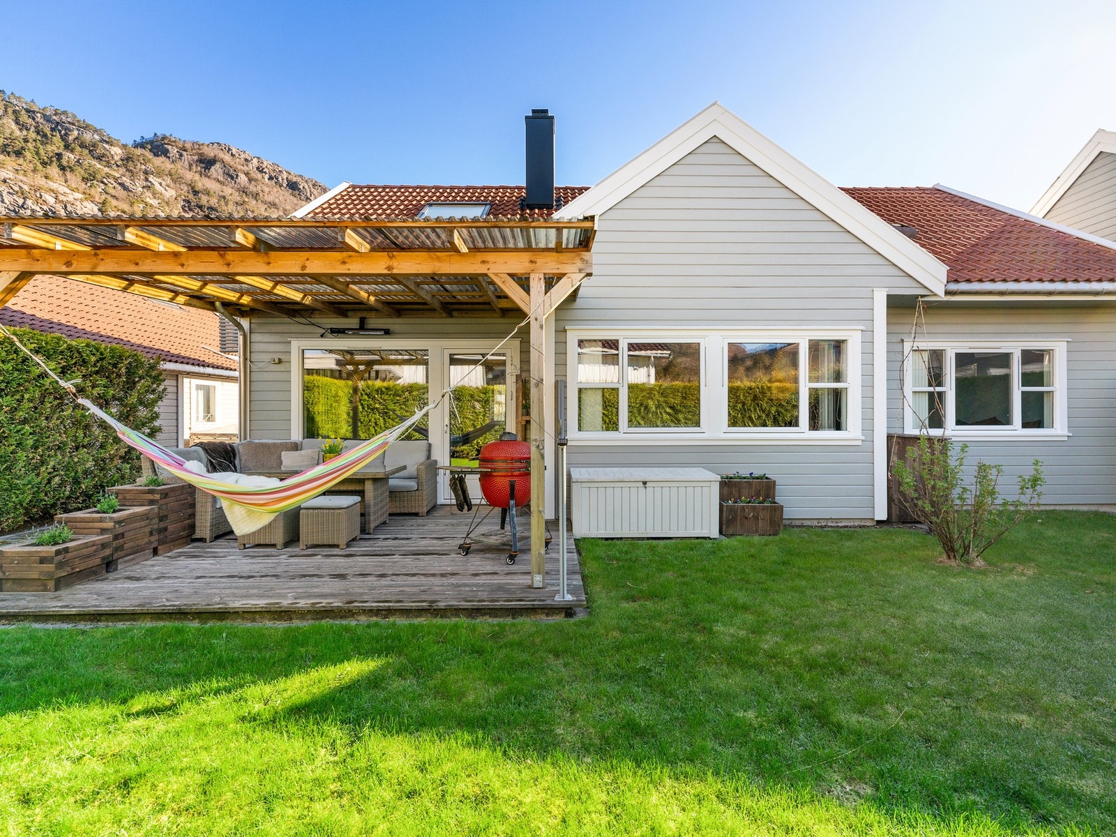 Fra stuen kommer man ut til boligens uteområde som består av terrasse og plen. Galleribilde