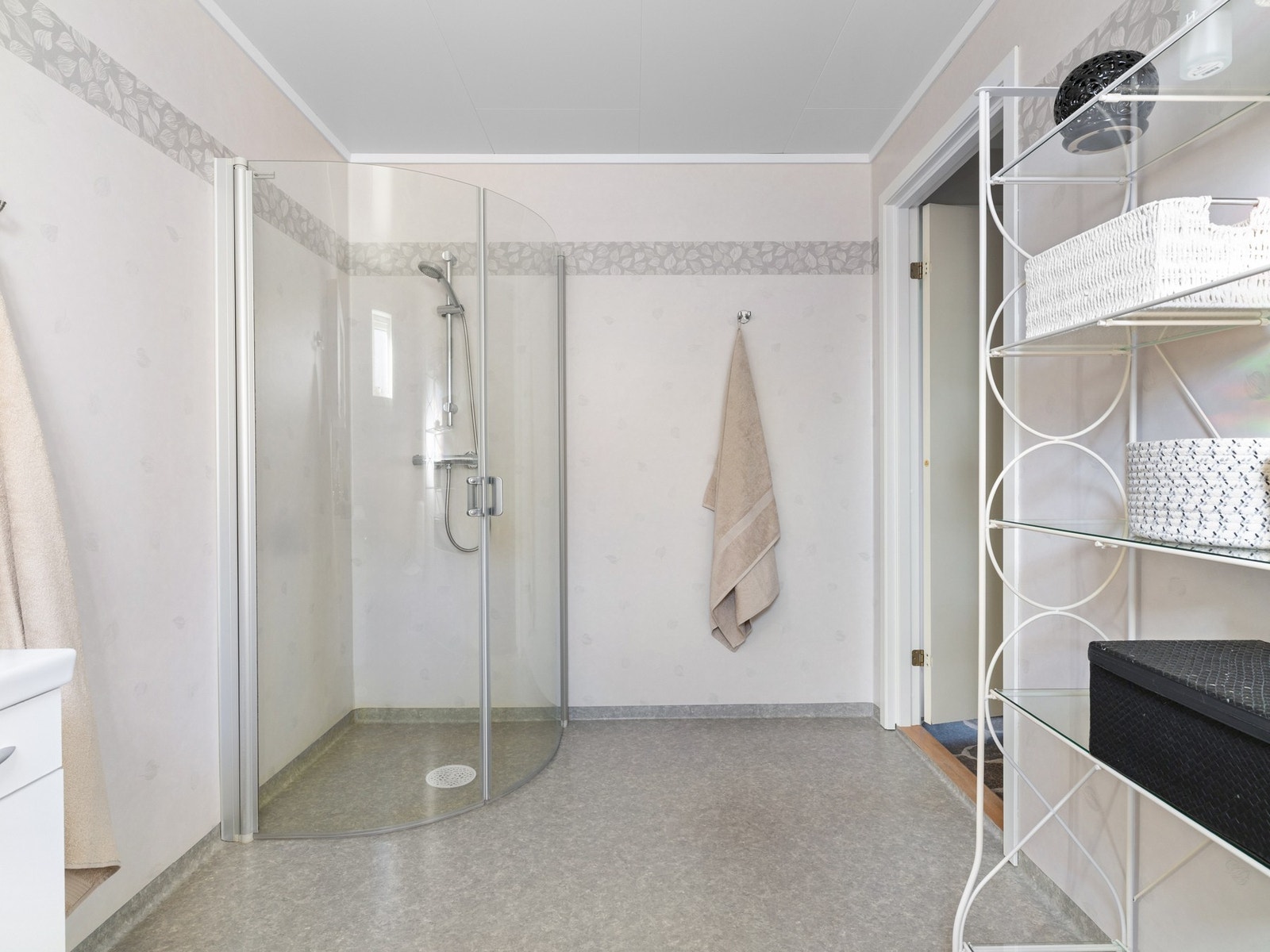 Badet er innredet med servant på skapseksjon og speil. Videre er badet utstyrt med toalett og innfellbare dusjvegger. Galleribilde