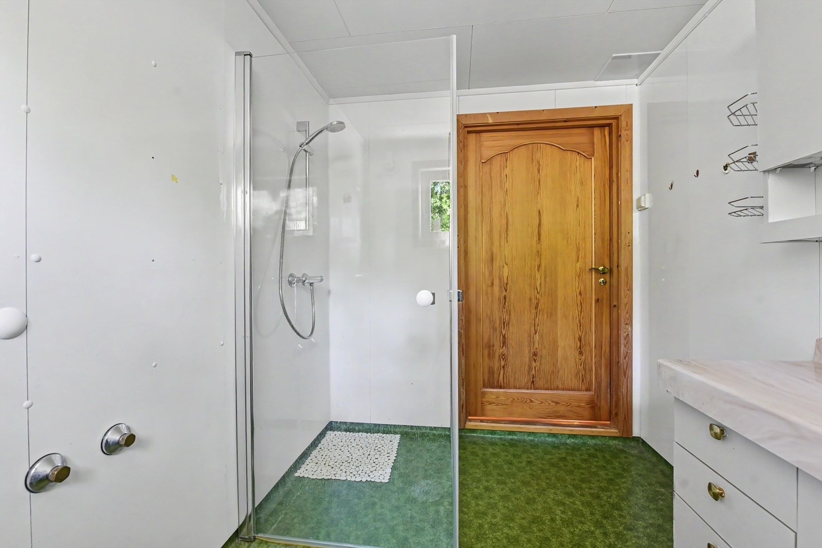 Badet er utstyrt med dusjhjørne og servant. Galleribilde