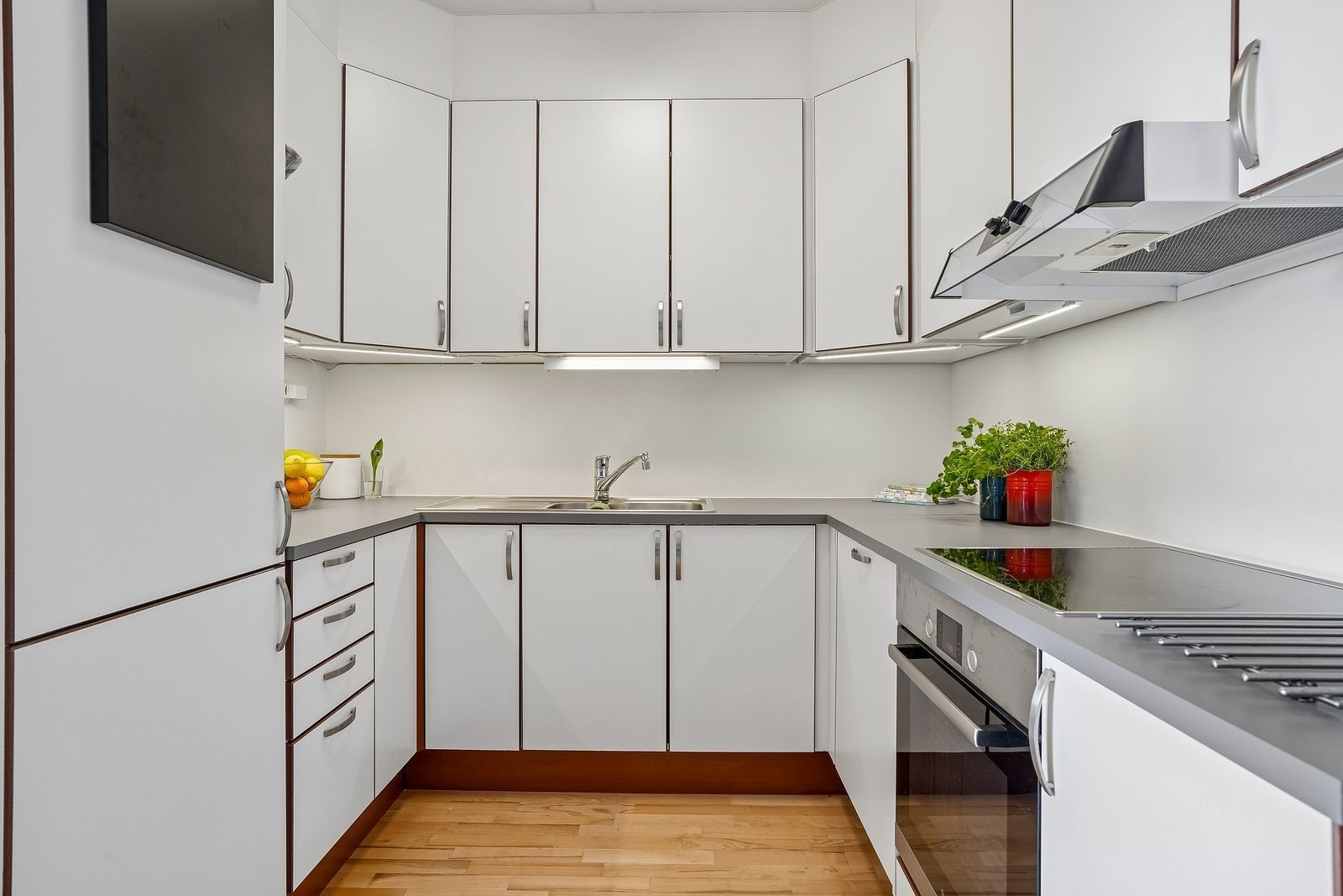 Pent kjøkken med integrerte hvitevarer. Rikelig med skap- og benkeplass.