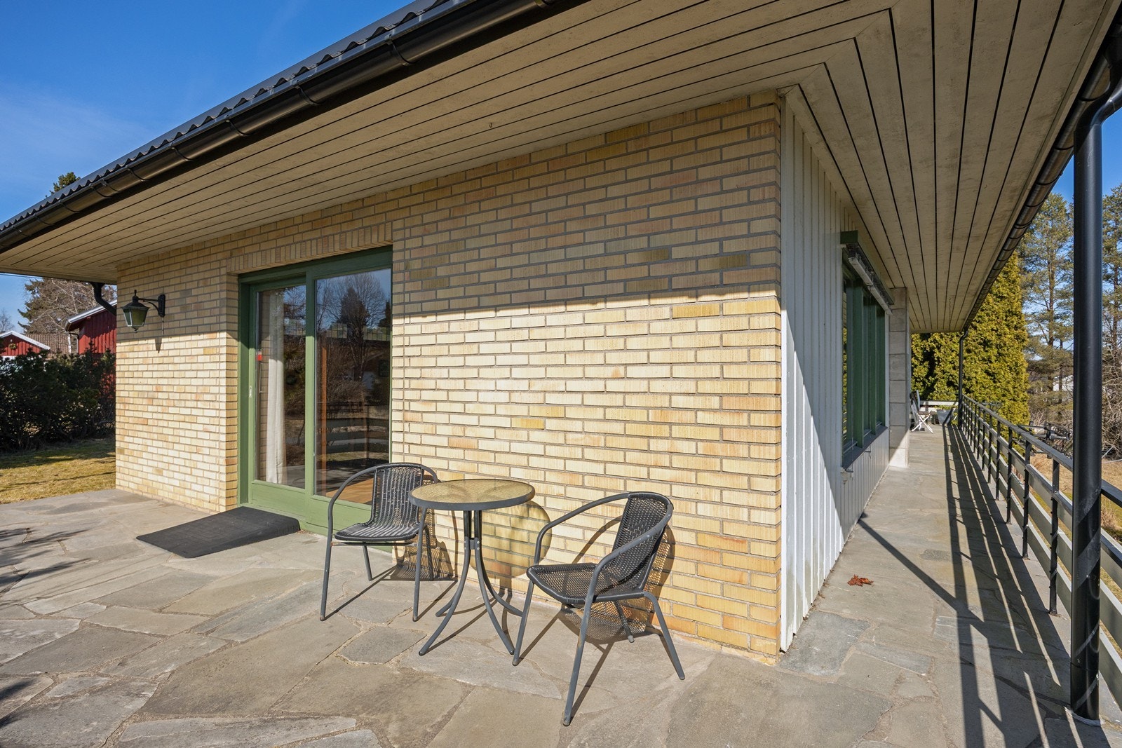 Det er støpt, skiferlagt dekke, og terrassen rammes inn med rekkverk i metall og tre. Galleribilde