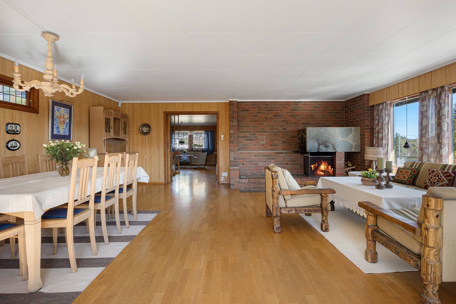 Fra den største stuen er det utgang til terrasse og hage. I tillegg til radiatorer har rommet en åpen, oppmurt peis for ekstra hygge. Galleribilde