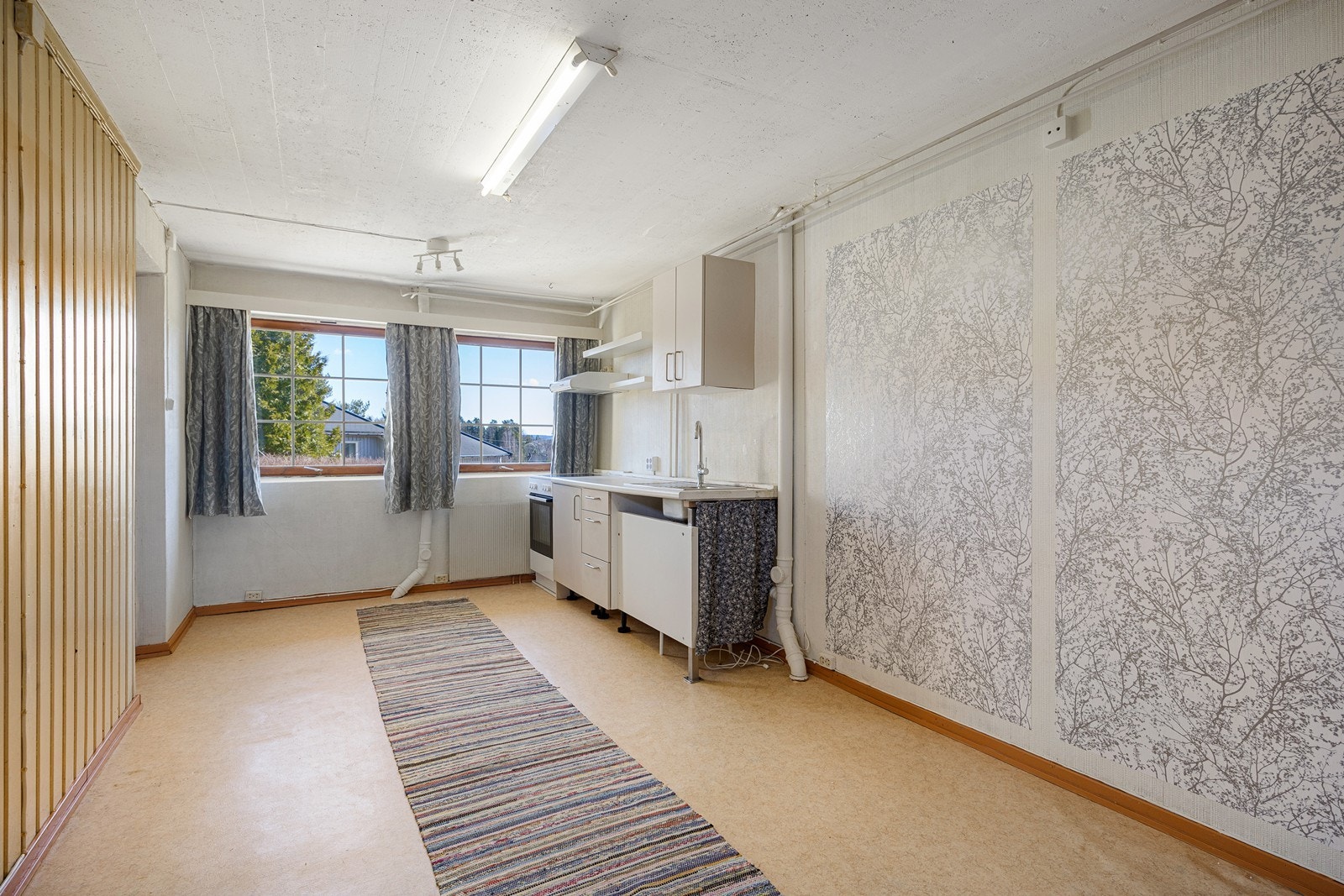 Underetasjen har separat utvendig sideinngang inn til en liten entre. Innenfor entreen er det et innredet rom tatt i bruk som kombinert kjøkken og stue. Dette rommet er ikke et godkjent oppholdsrom, men et hobbyrom i følge godkjente byggetegninger. Galleribilde