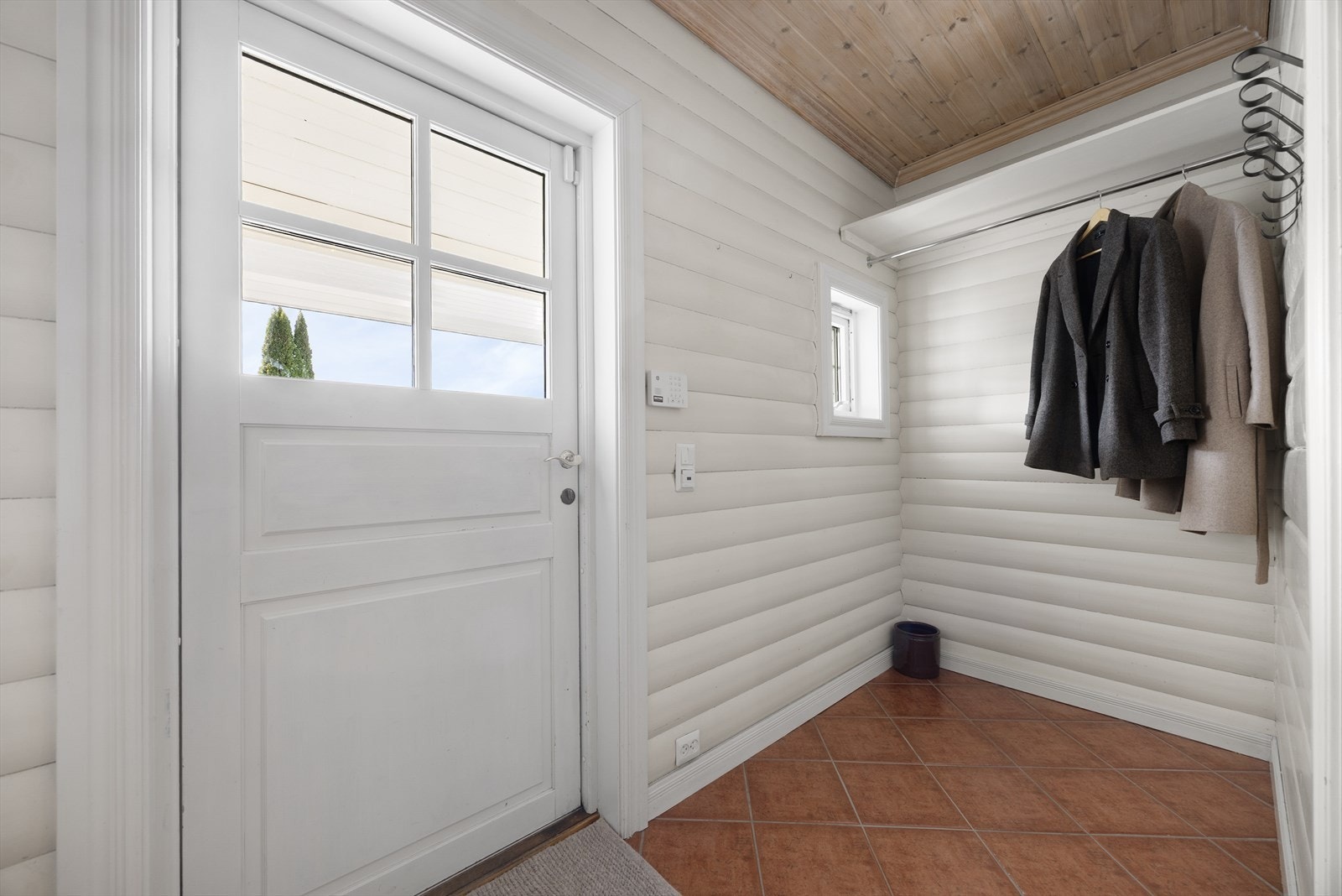 Lys og romslig entré i tilbygget del fra 1997. Her er det flislagt gulv med varmekabler og praktisk nisje for oppbevaring av sko- og yttertøy. Galleribilde