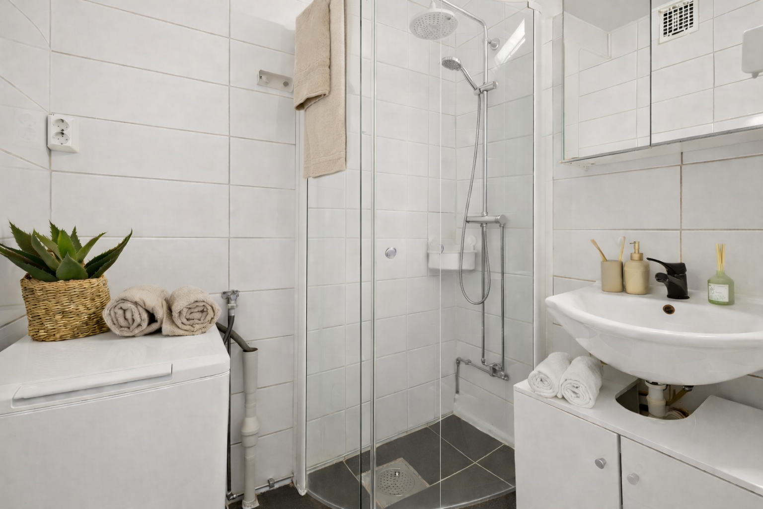 Baderommet ble oppgradert i ca. 2020, med fliser på gulv og vegger. Her er det dusjhjørne med glassvegger og opplegg for vaskemaskin. Galleribilde