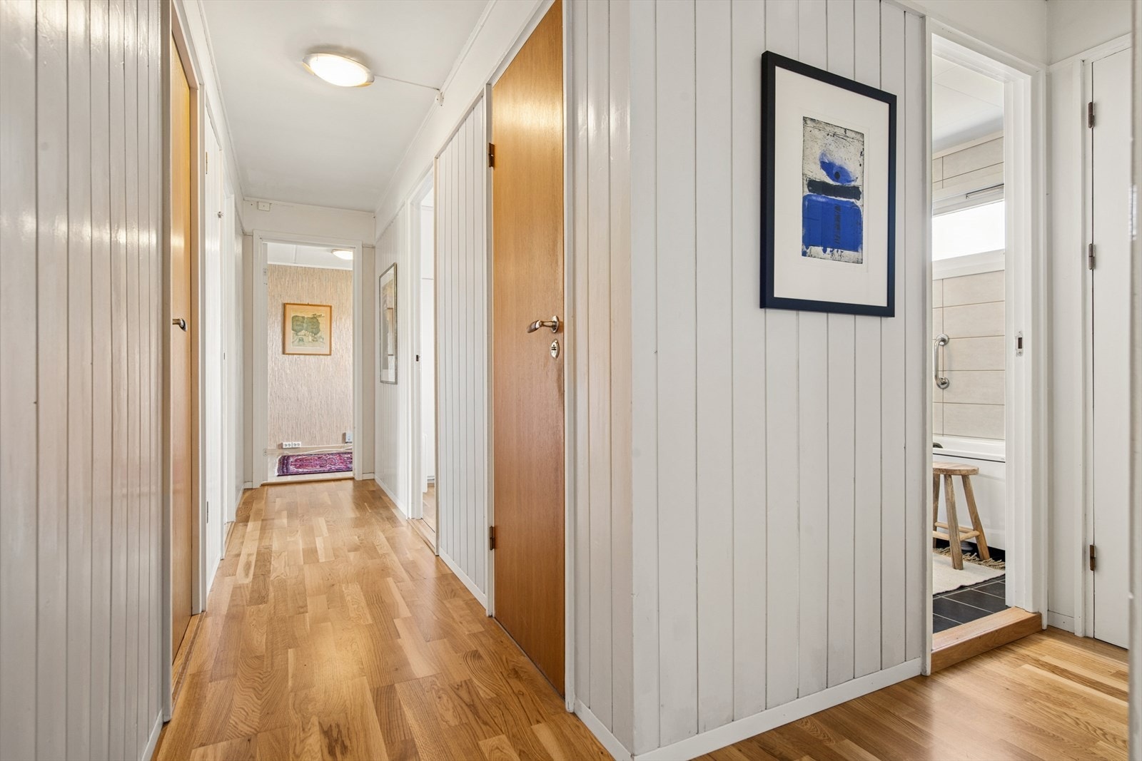 Gangen binder sammen soverommene, badet og toalettrommet. Gulvet har parkett, og veggene er kledd med trepanel. Galleribilde