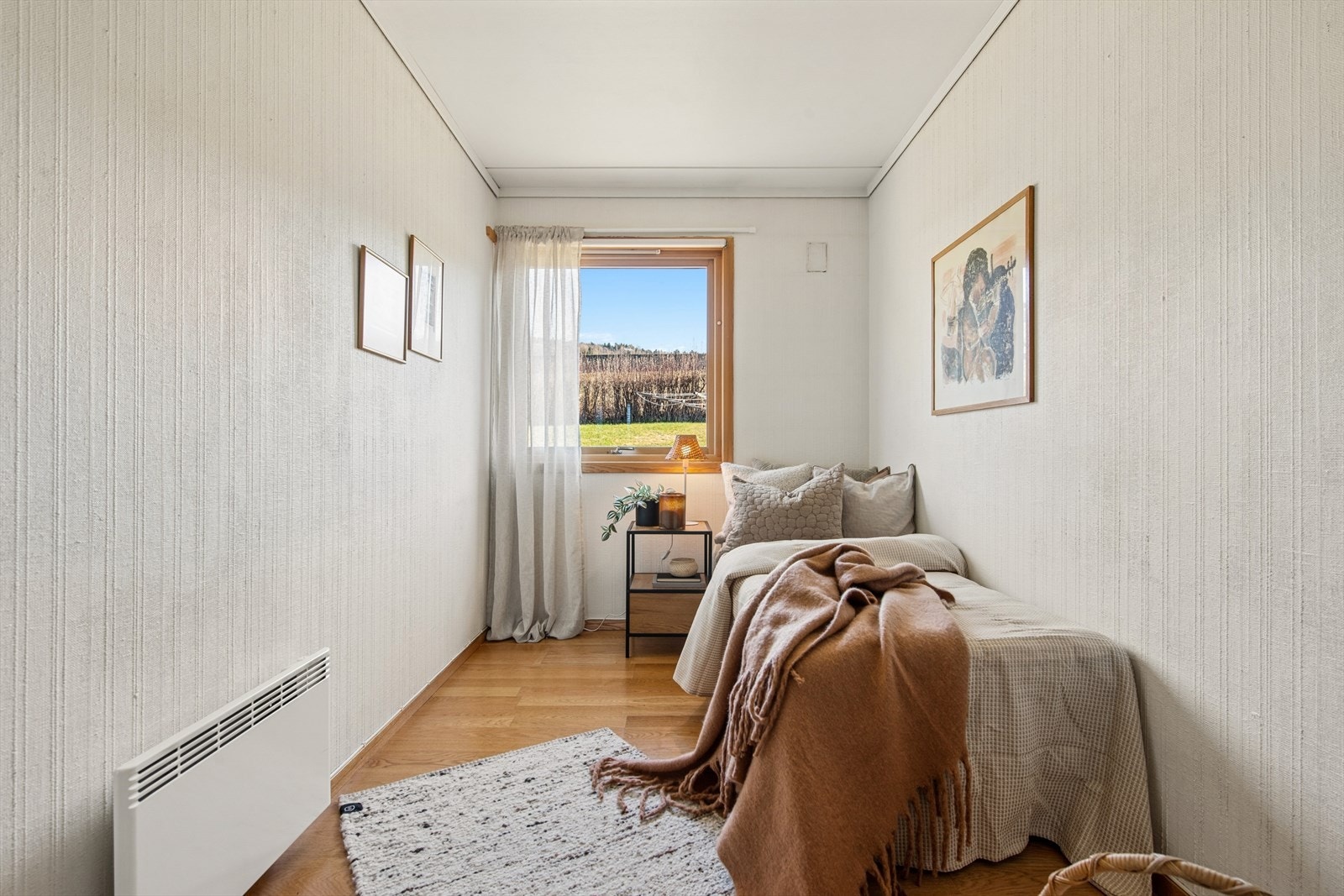 Vinduet gir utsyn mot hagen og slipper inn dagslys. Galleribilde