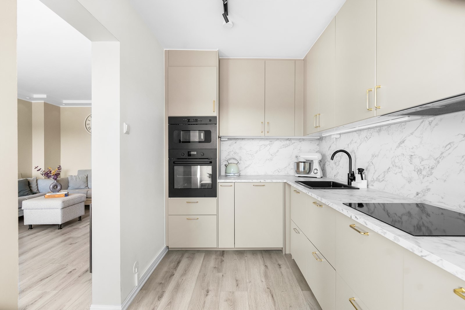 Kjøkkenet har en lys og moderne IKEA-innredning med glatte hvite fronter, laminat benkeplate og nedfelt komposittkum med ettgreps kjøkkenkran. Galleribilde