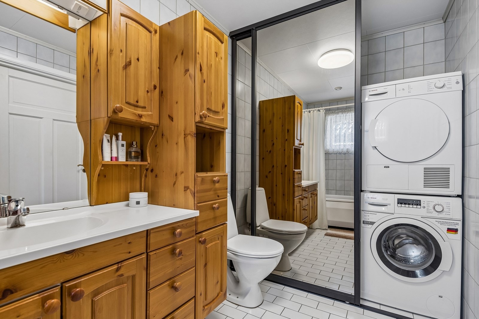 Badet i første etasje er flislagt og har gulvvarme. Rommet fungerer også som vaskerom med opplegg for vaskemaskin og tørketrommel. Galleribilde