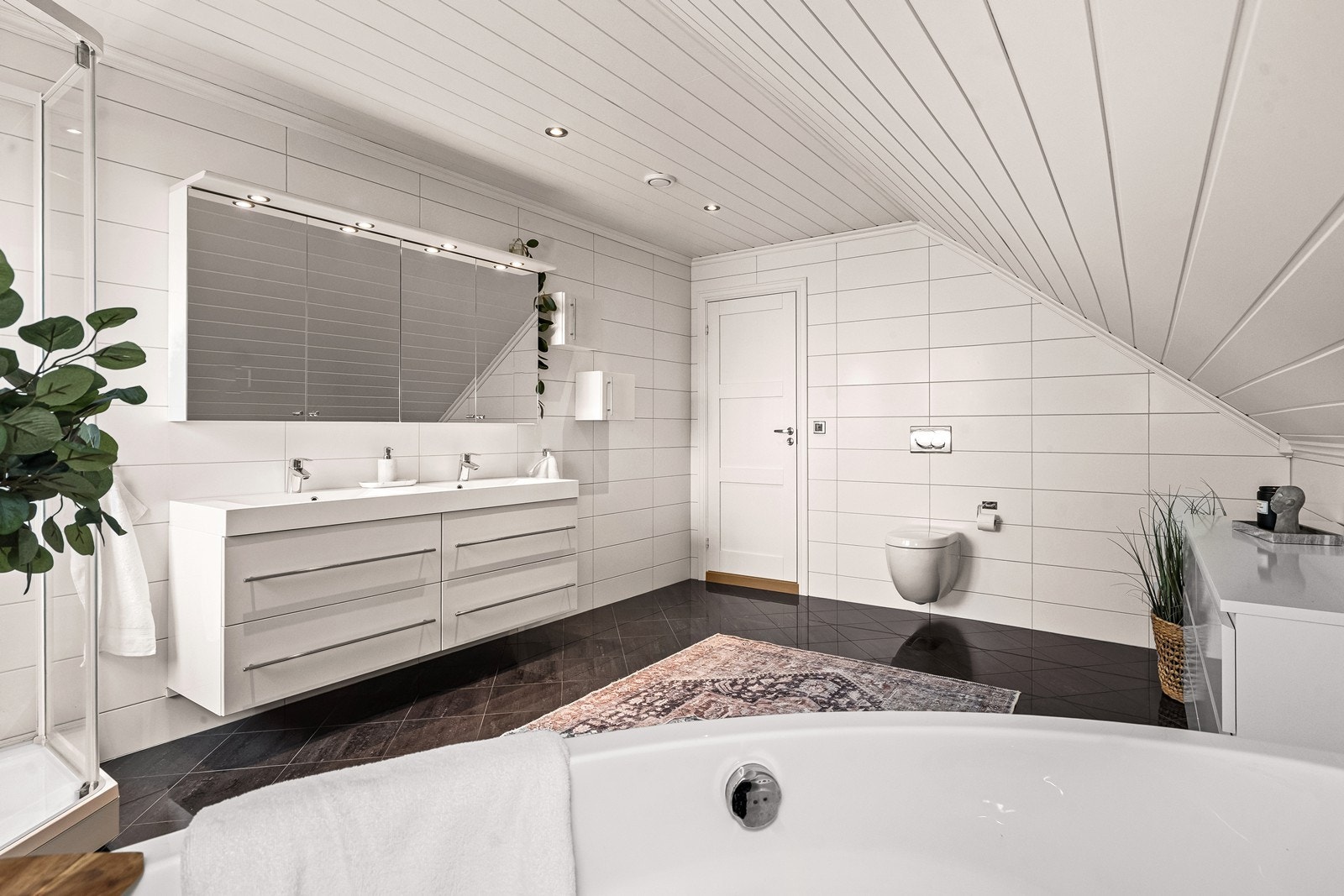 Badet har flislagt gulv med vannbåren gulvvarme og mdf-panel i taket. Galleribilde