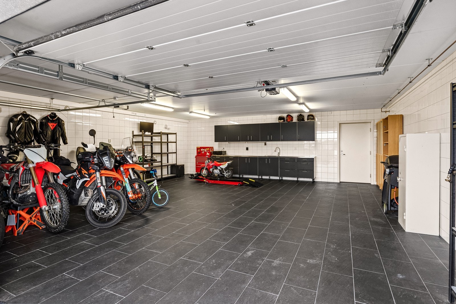 Den integrerte garasjen på ca. 65 m² har flislagt gulv med vannbåren varme og to leddporter. Galleribilde