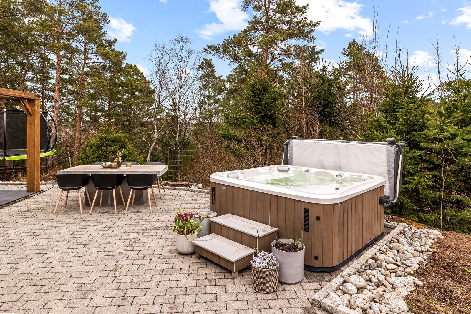Jacuzzien er pent integrert i det opparbeidede uteområdet. Galleribilde