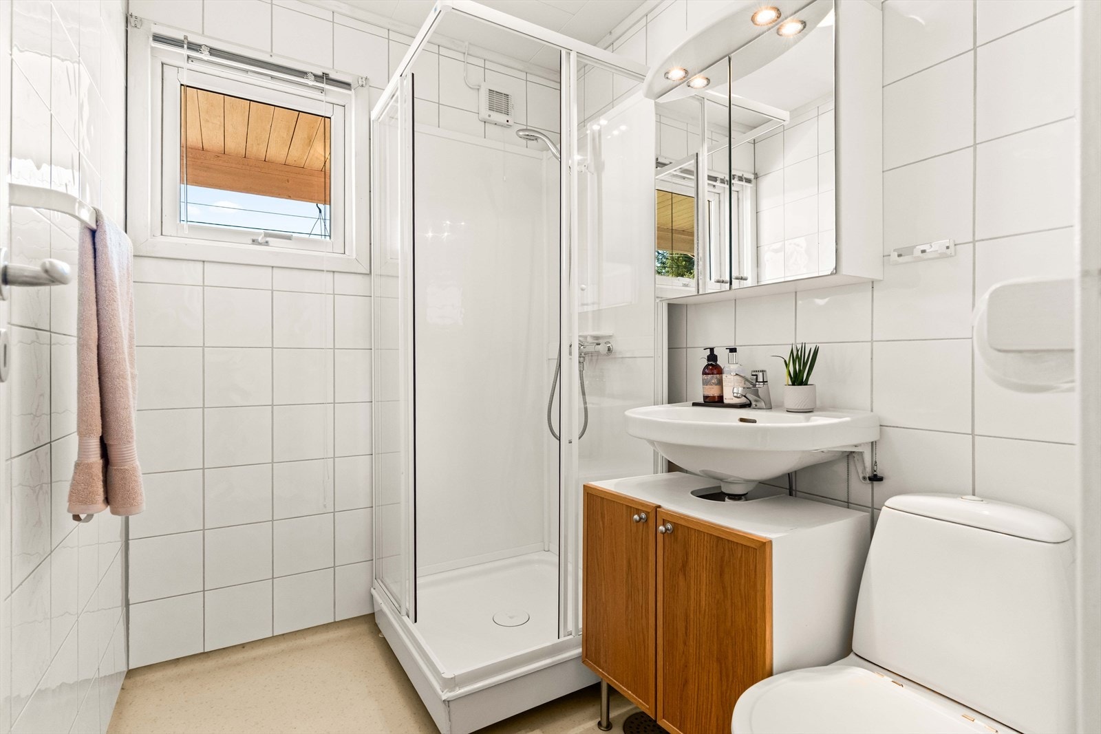 Boligen inneholder et bad/wc og et vaskerom/wc. Badet ligger i første etasje, og har hvite fliser på veggene og beige belegg på gulv med sluk. Galleribilde