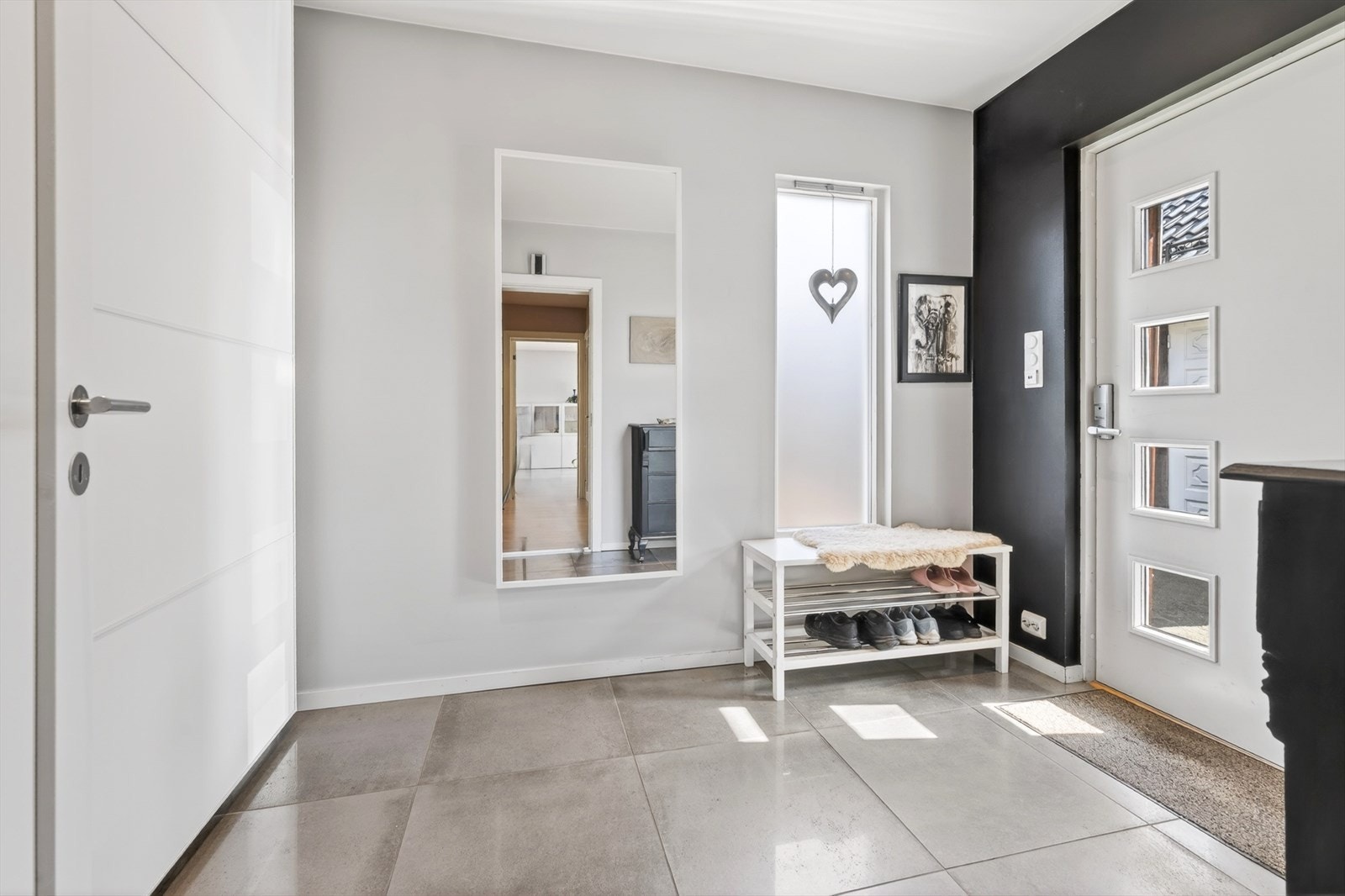 Hyggelig entré med fliser, varmekabler og pen skyvedørsgarderobe Galleribilde