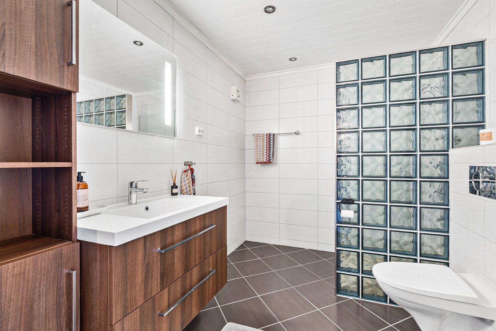 Badet er moderne og er helfliset. Her er det varmekabler i gulv og spotter i tak. Galleribilde
