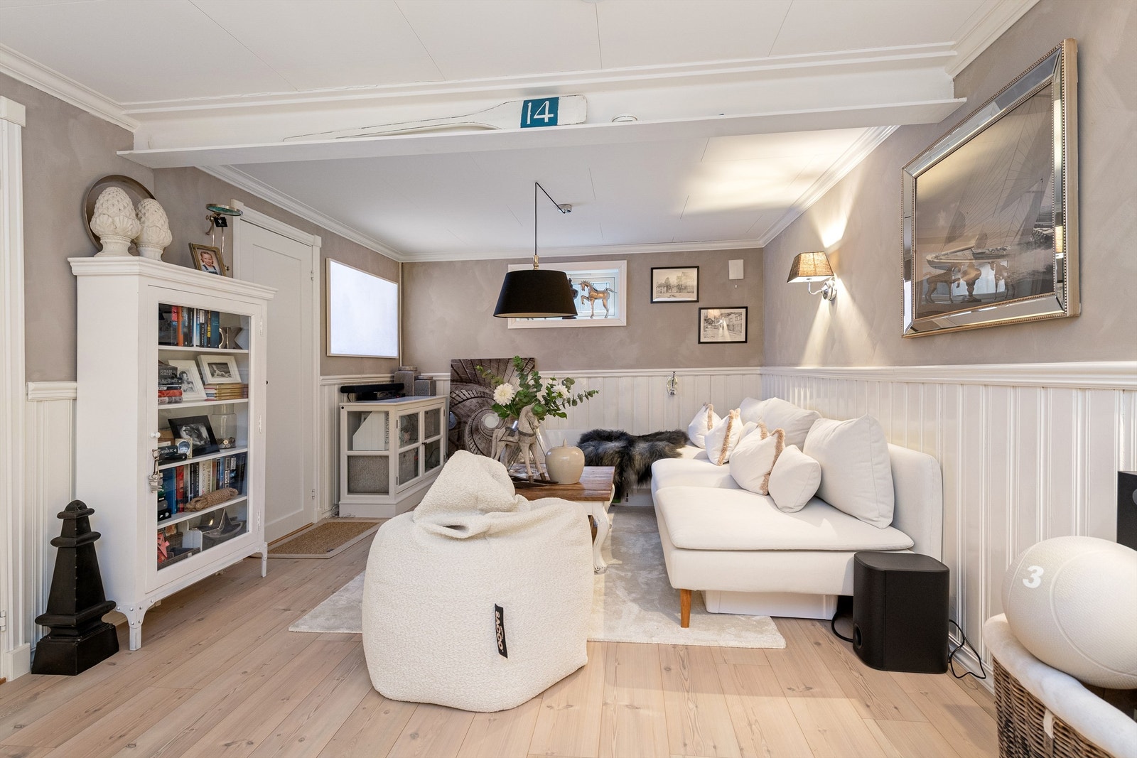 Kjellerstuen har en-stavs laminat på gulvet og en kombinasjon av malt brystningspanel og tapet på vegger Galleribilde