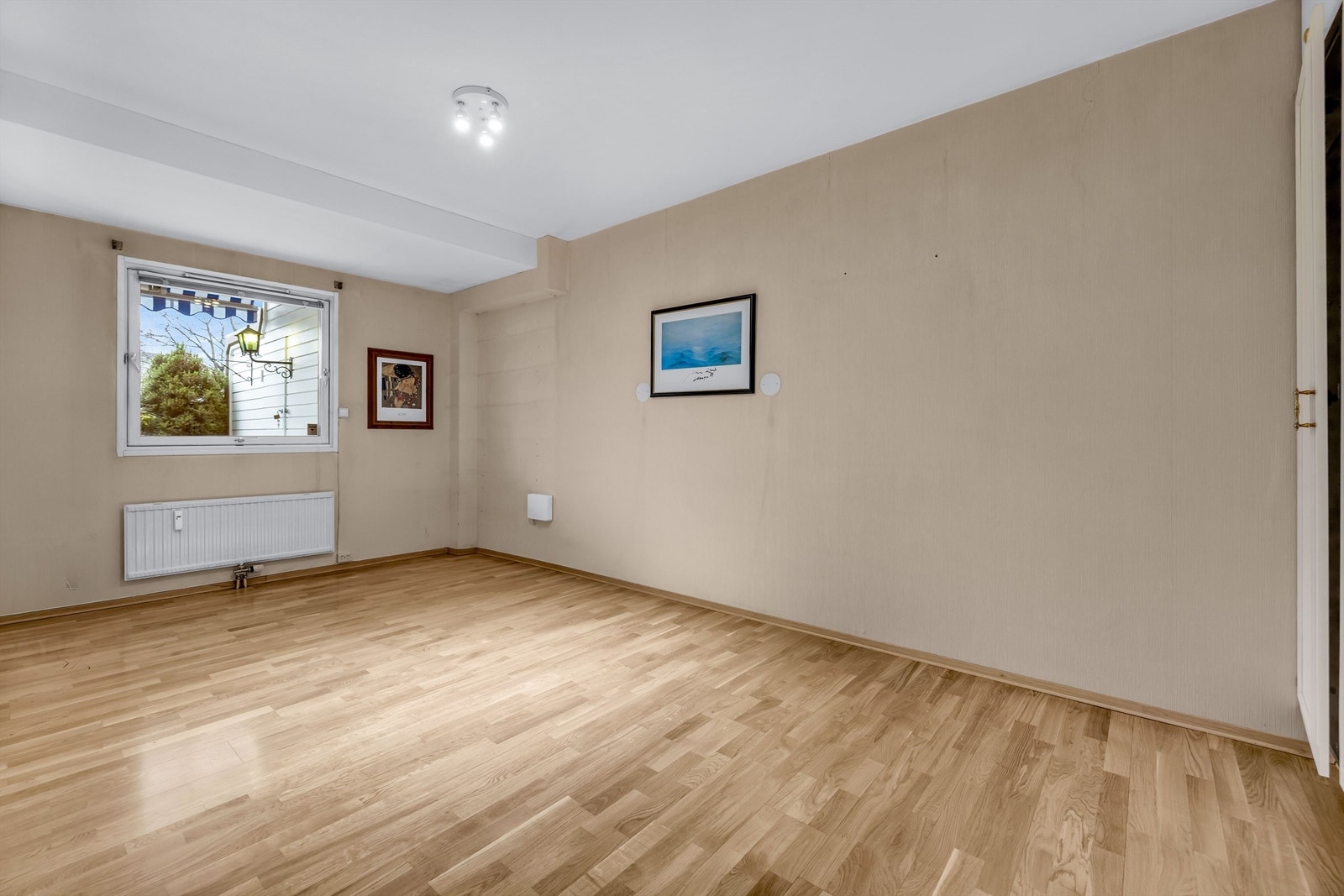 Stort soverom med pen parkett på gulv og vegger med behov for overflatebehandling. Galleribilde