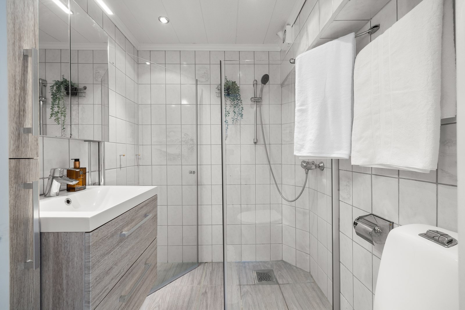 Lyst og fint flislagt baderom med downlights i himlingen og elektrisk gulvvarme. Selger har skriftlig bekreftelse fra styret på at badet er planlagt renovert i 2028. Galleribilde