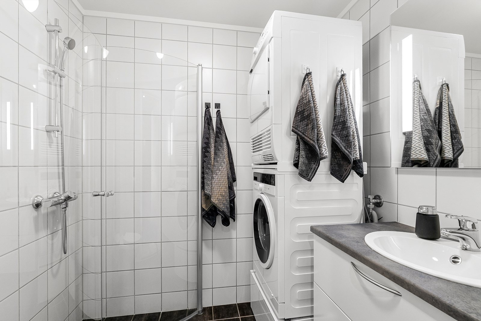 Badet i hoveddelen er flislagt og har behagelige varmekabler i gulv. Badet er utstyrt med dusjhjørne, toalett, lys baderomsinnredning og opplegg for vaskemaskin/tørketrommel. Galleribilde