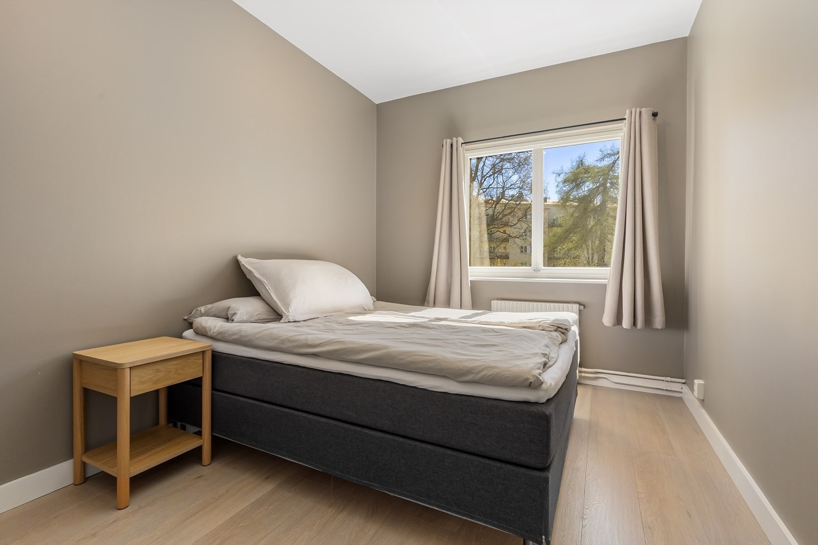Romslig hovedsoverom med dobbeltseng og garderobe, vendt mot bakgård. Galleribilde