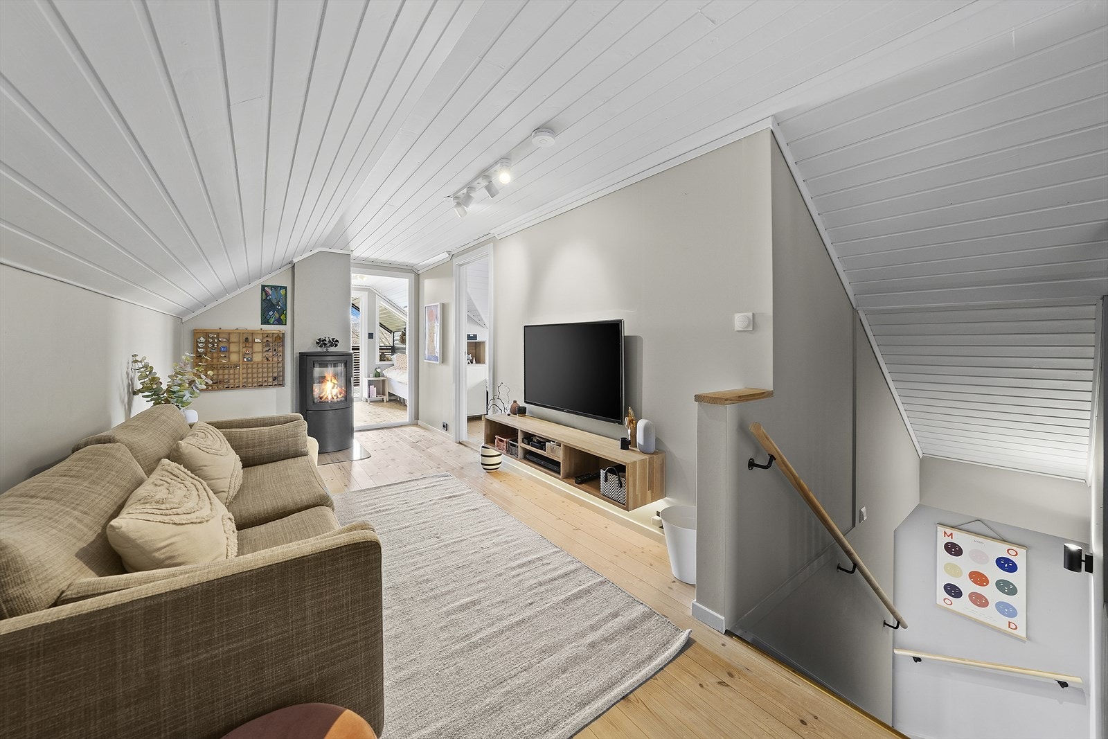 Lys og praktisk loftstue med plass til sofa og TV-møblement Galleribilde