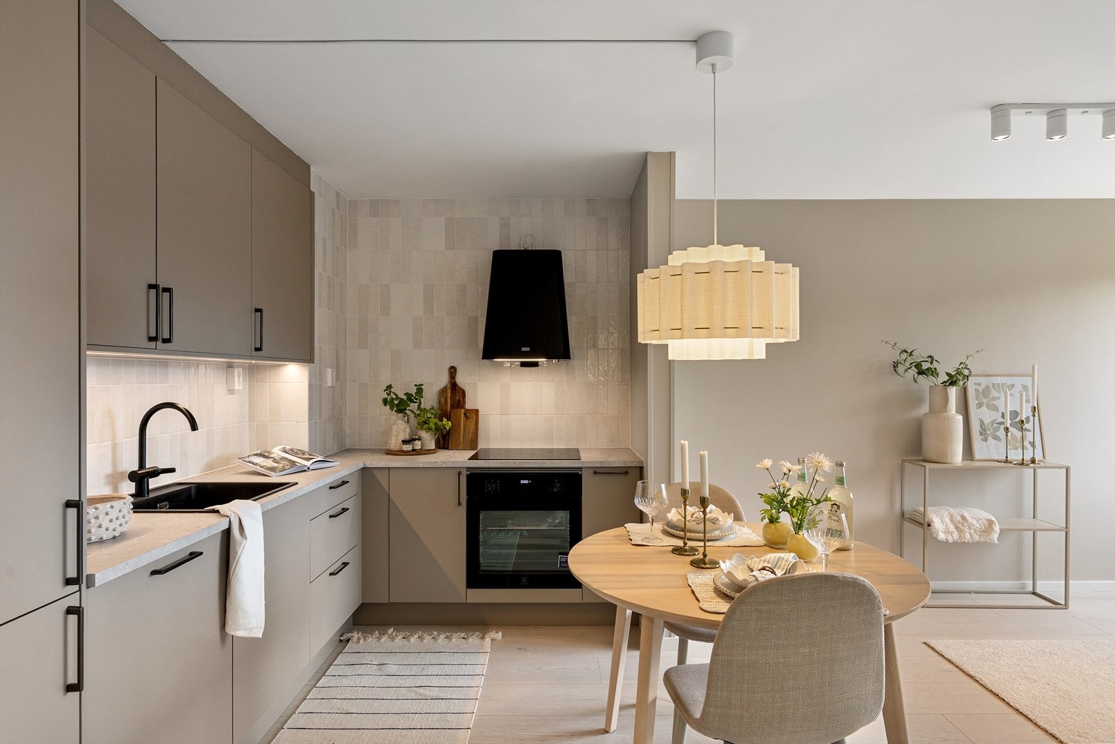 Laminat benkeplate med integrert oppvaskkum og ettgreps blandebatteri, samt fliser mellom benkeplate og overskap, bidrar til et helhetlig og funksjonelt uttrykk. Galleribilde
