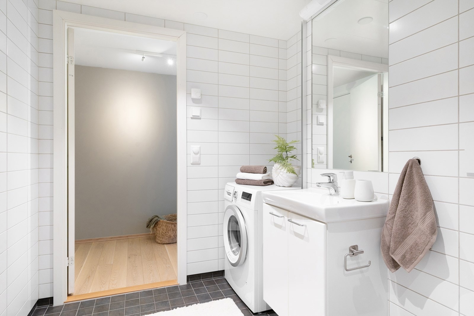 Badet er innredet med vegghengt toalett, dusjhjørne med vegger/dør i herdet glass, samt servant med tilhørende skap, speil og belysning. Det er opplegg for vaskemaskin. Galleribilde