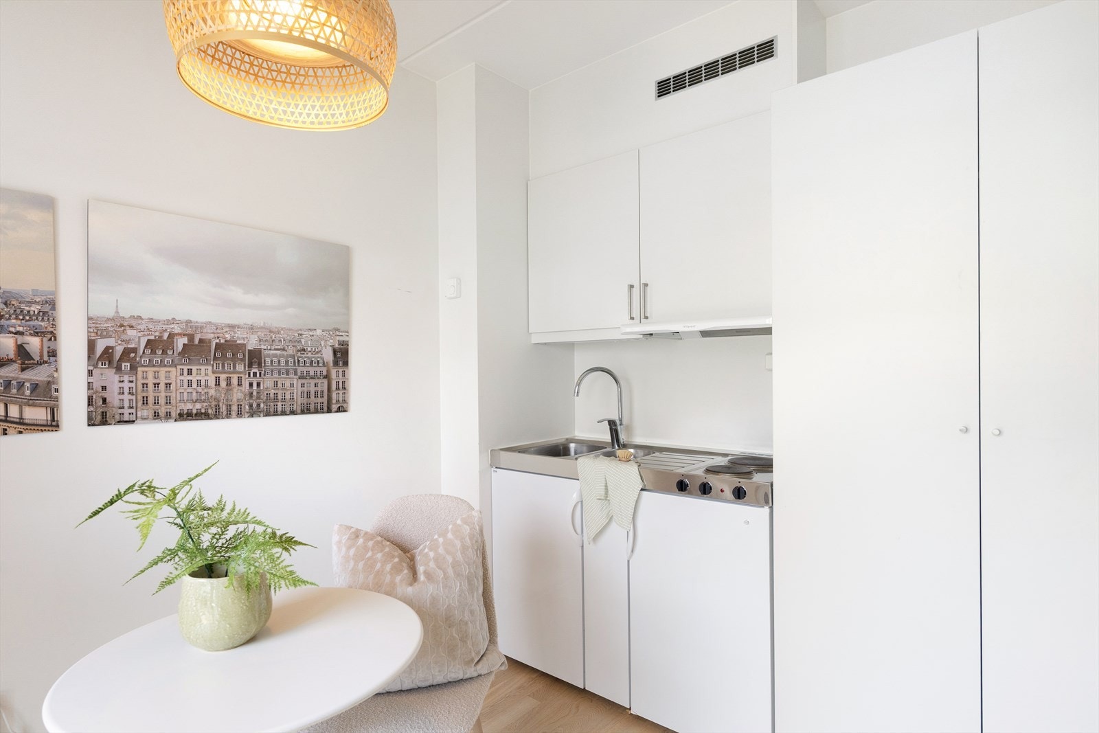 Hybelkjøkken med slette fronter og benkeplate i rustfritt stål med integrert oppvaskkum og ettgreps blandebatteri. Det er integrert kjøleskap og platetopp, samt ventilator med kullfilter over kokeplass. Galleribilde