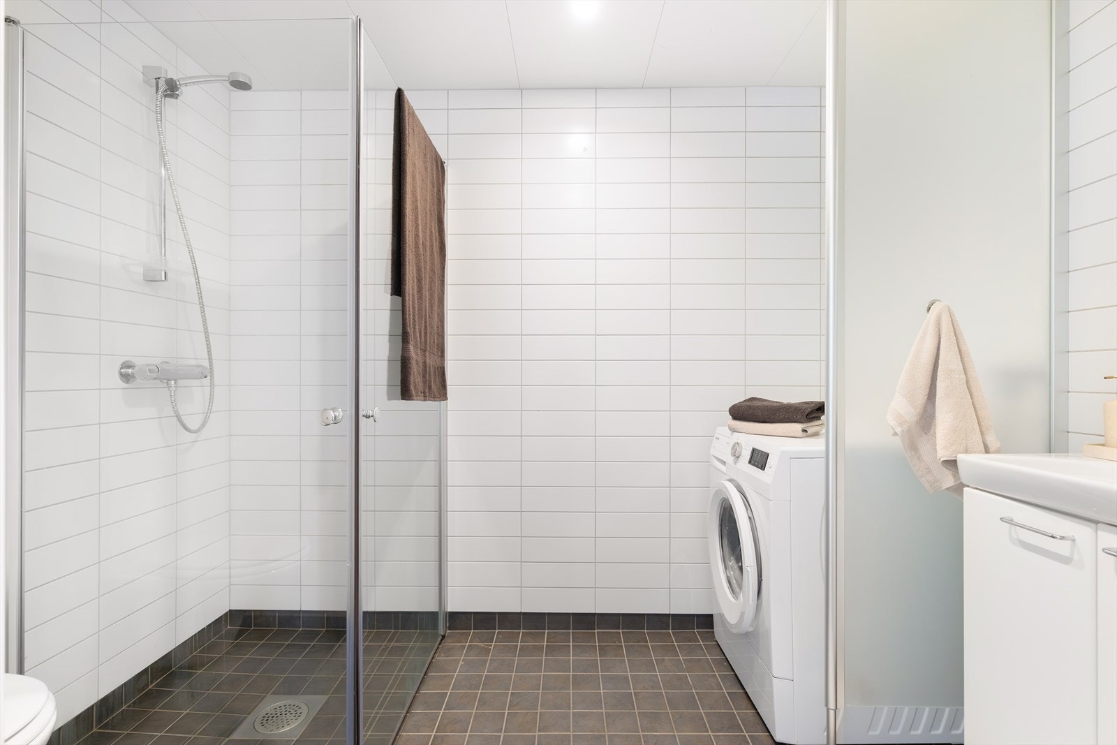 Pent og romslig flislagt baderom med downlights i himlingen og vannbåren gulvvarme. Galleribilde