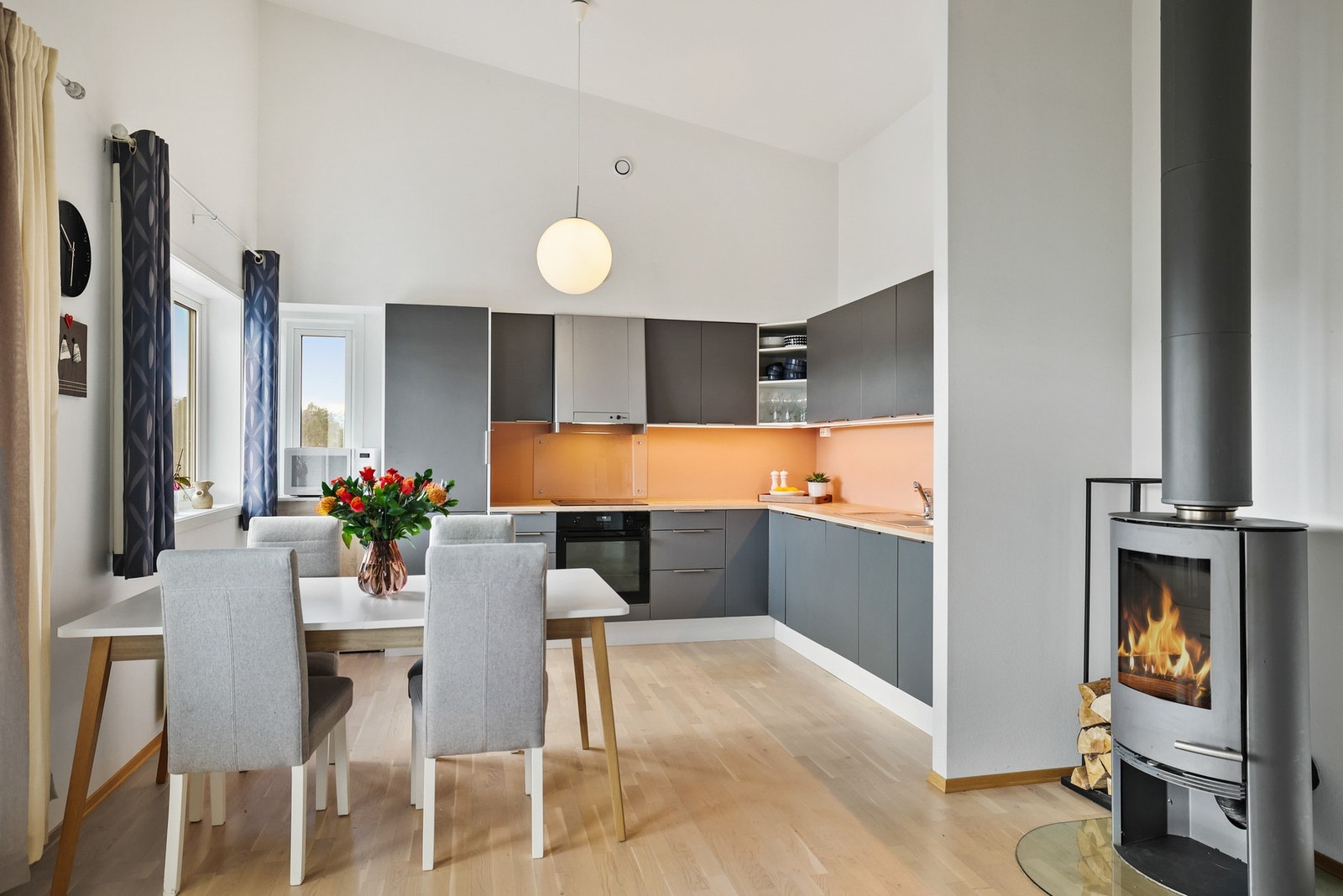 Åpen kjøkkenløsning med innredning med glatte fronter og benkeplate med laminert overflate. Galleribilde